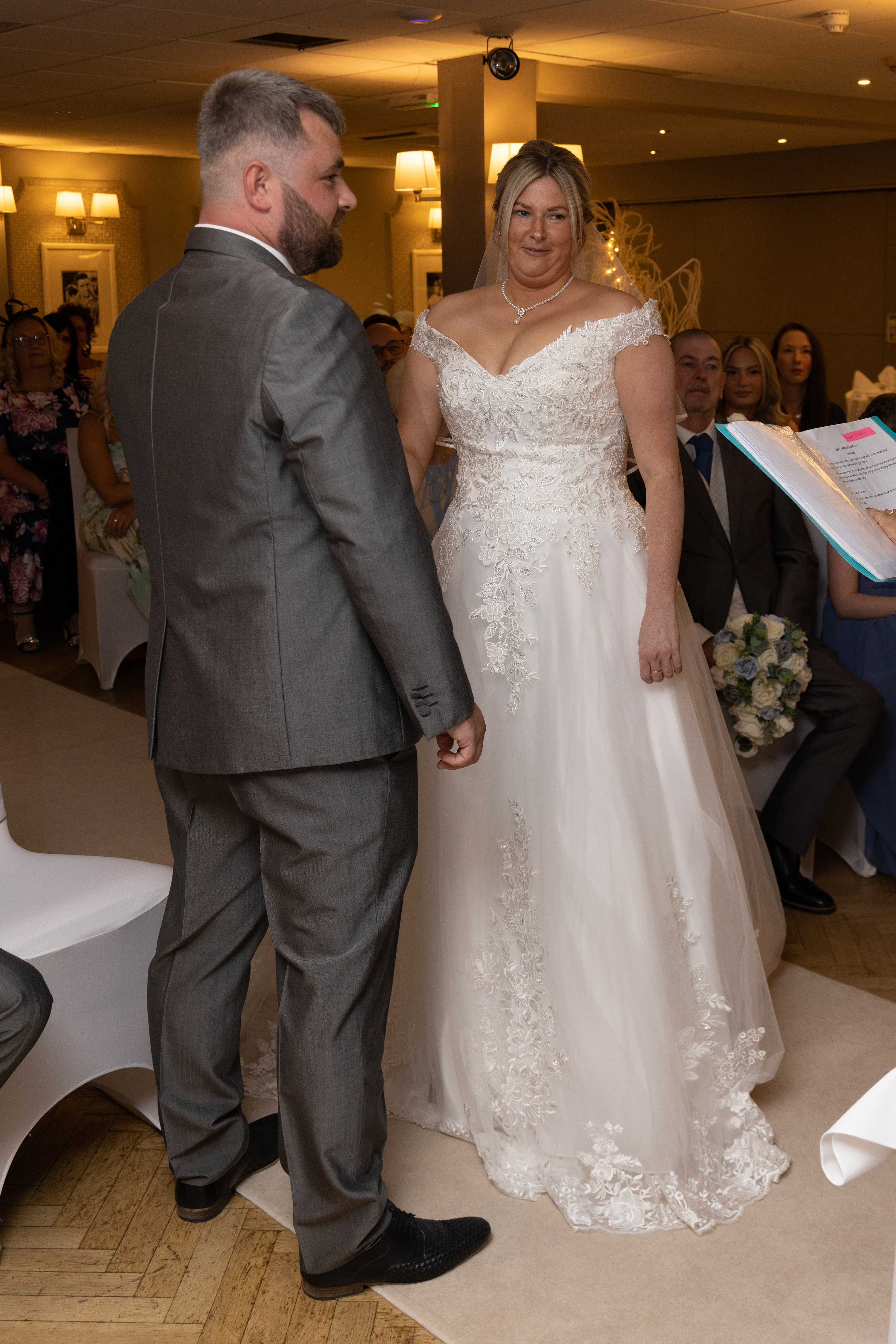 Bride and groom hold hands as they say their vows 