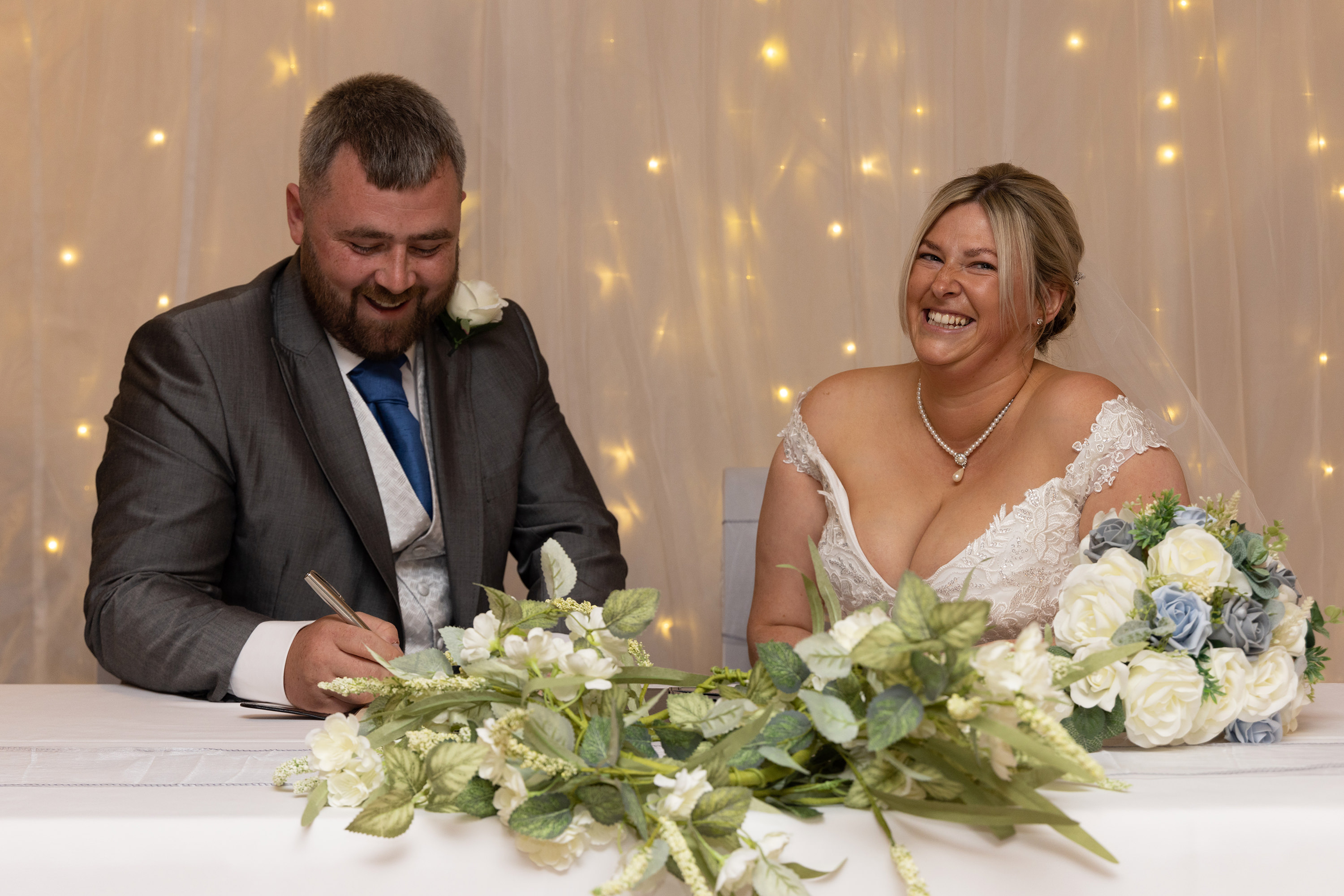 The bride and groom Gavin and Katie sign the wedding register