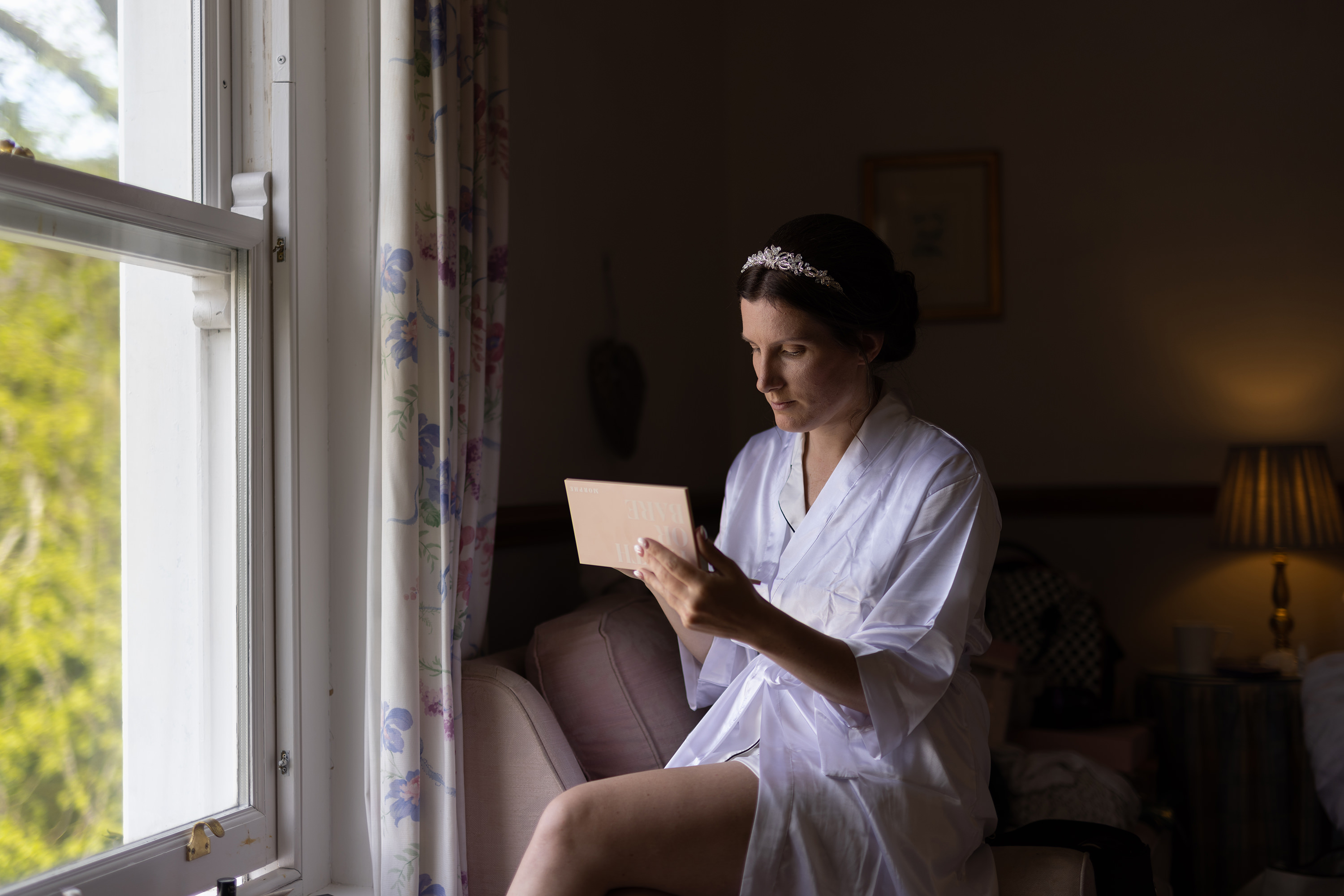Jane putting her makeup on in front of the window