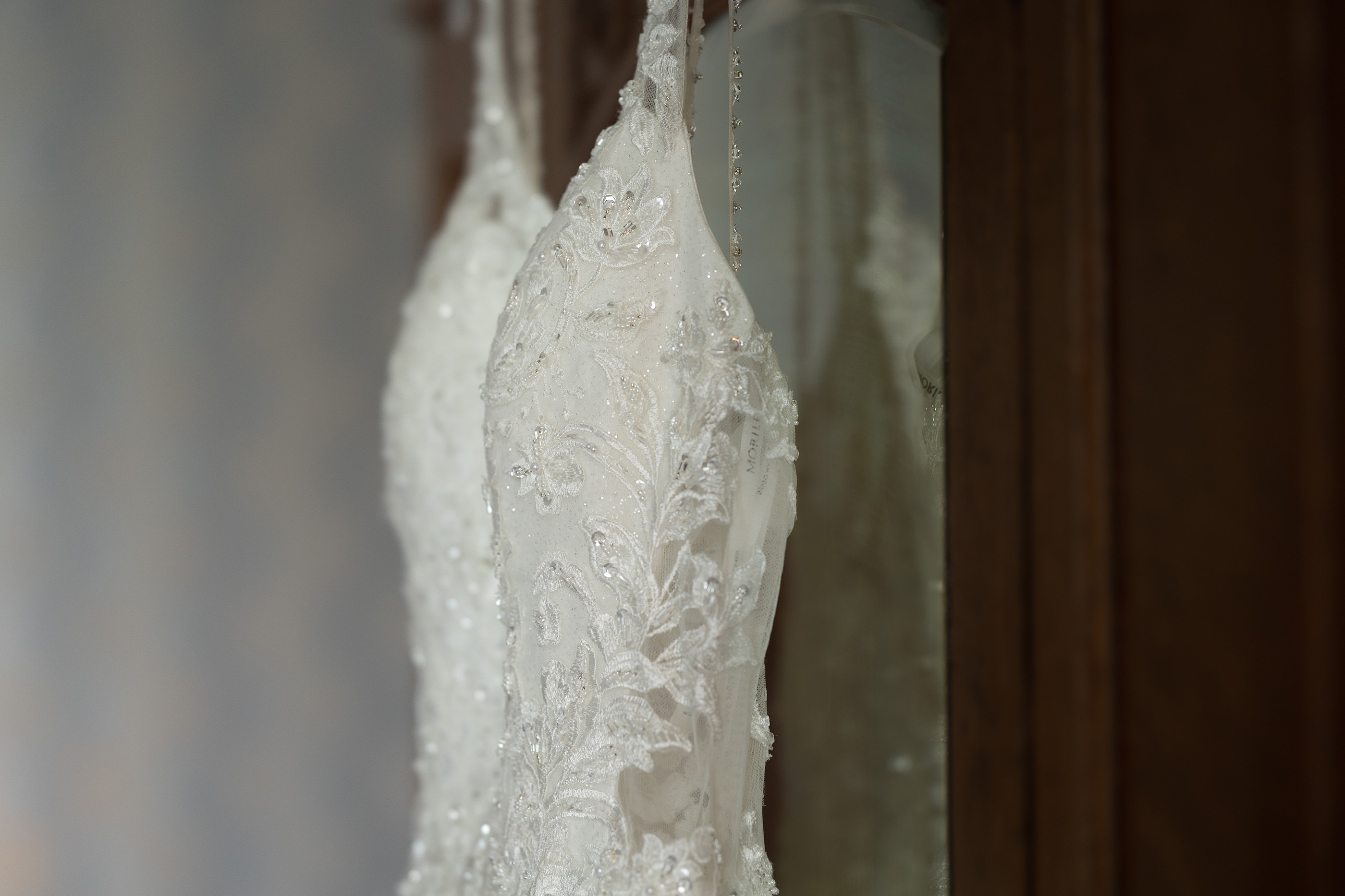Emily's wedding dress hanging on the wardrobe waiting to be put on 