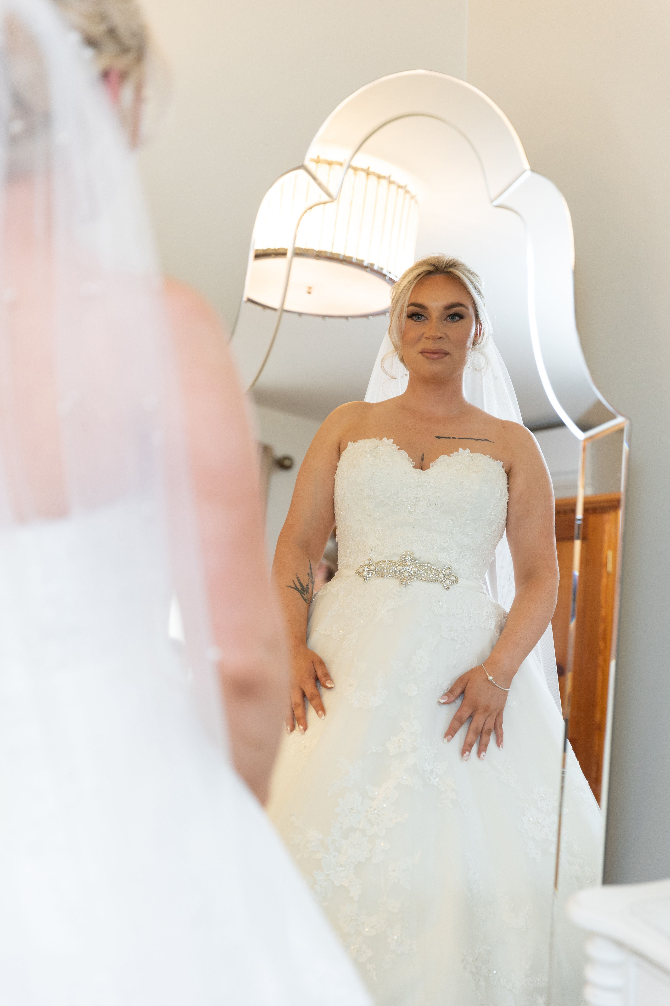 The Bride looking at her wedding dress in the mirror