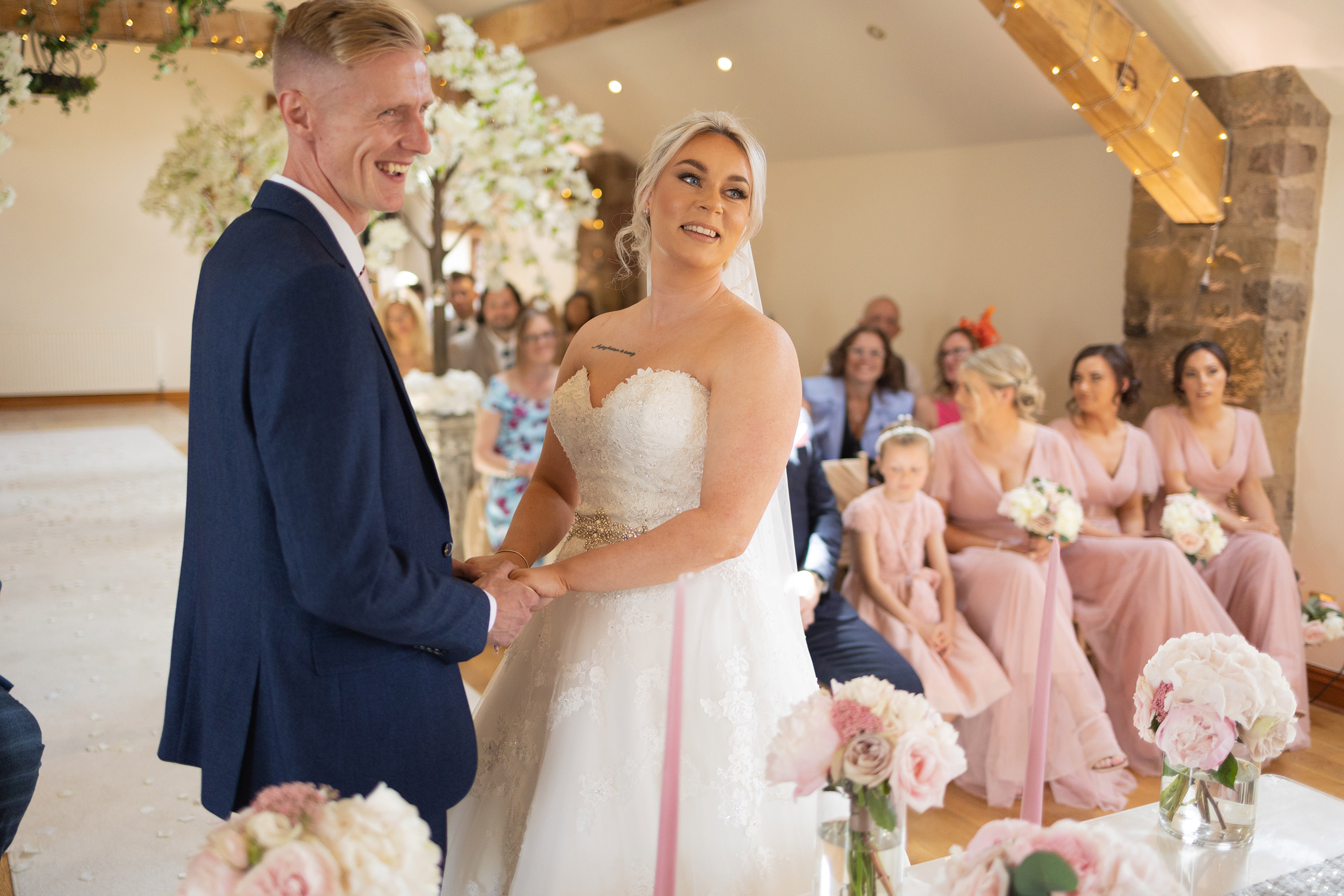 Gemma and Joshua hold hands during the wedding ceremony