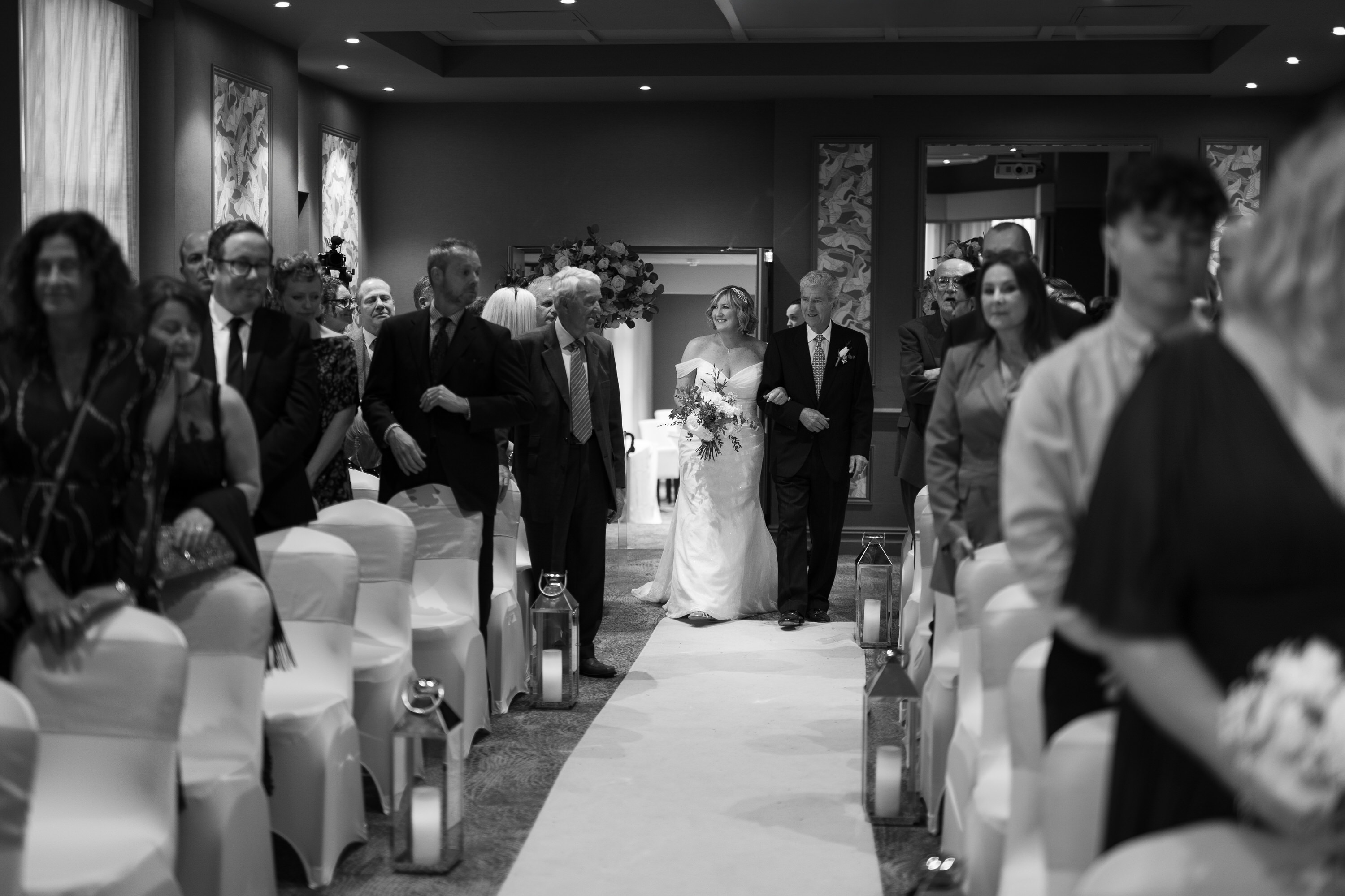 Lisa the Bride makes her way down the aisle with her father 