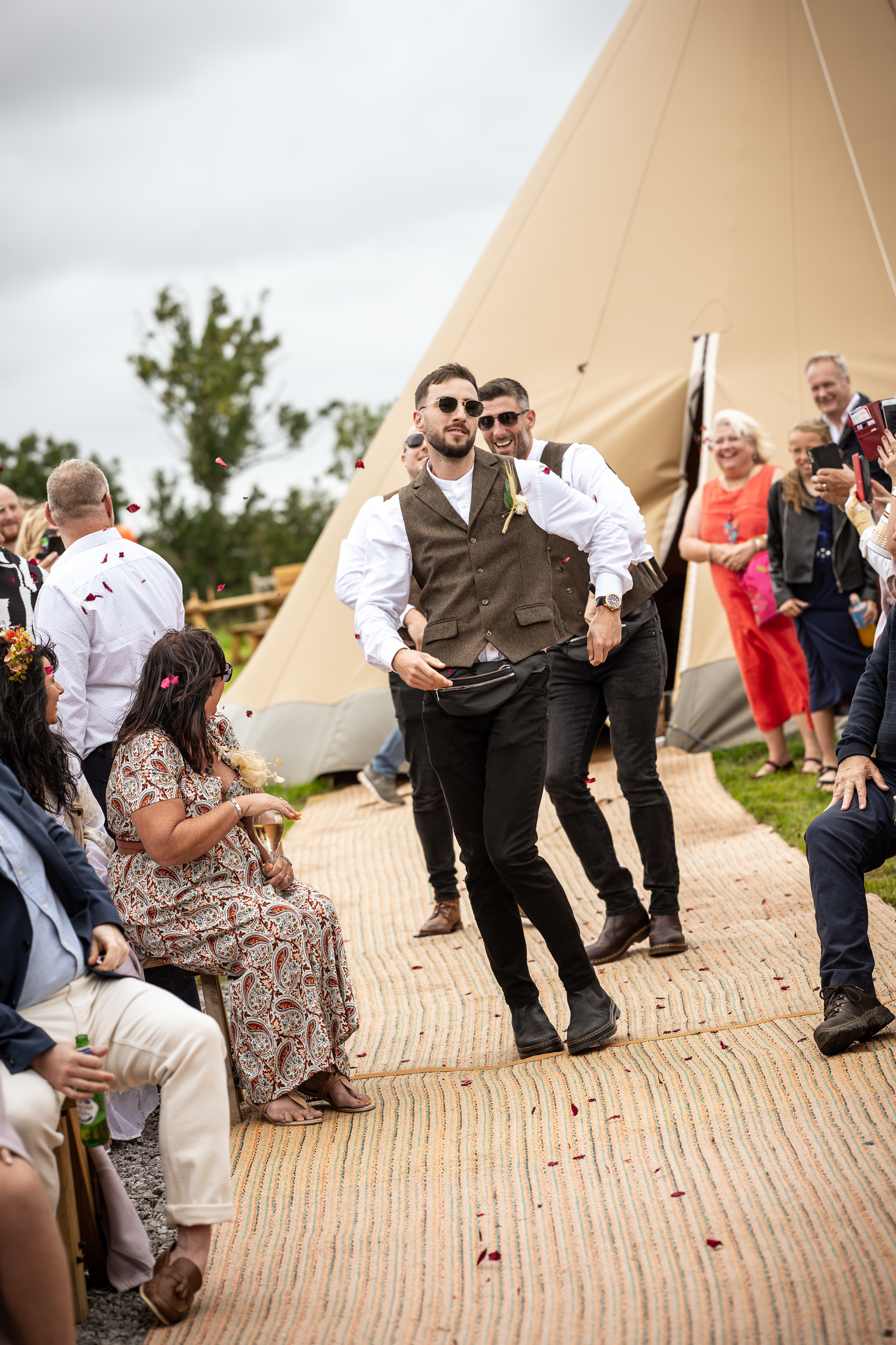 The groomsman make their way down the aisle throwing confetti 