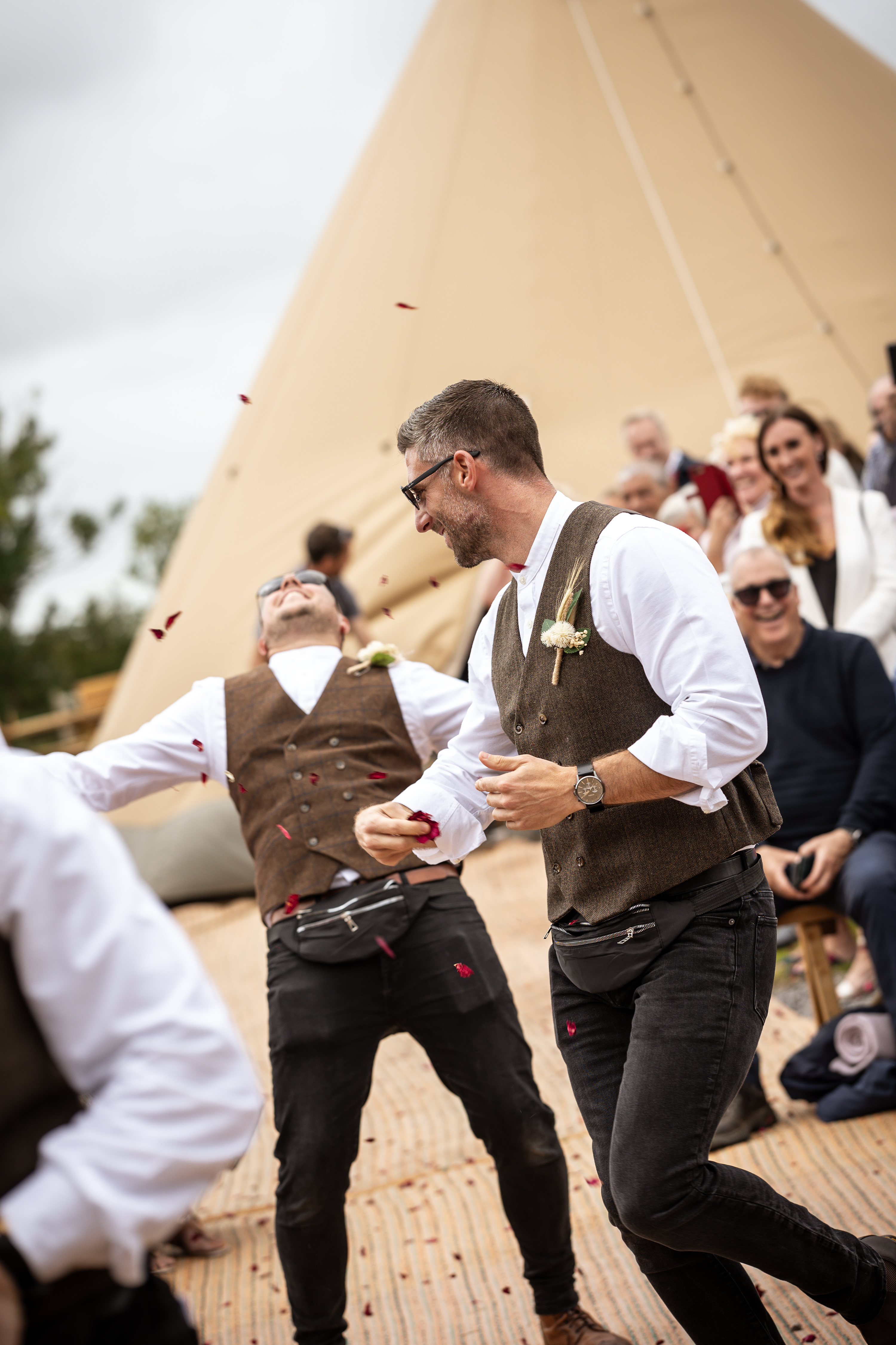 The groomsman make their way down the aisle throwing confetti 
