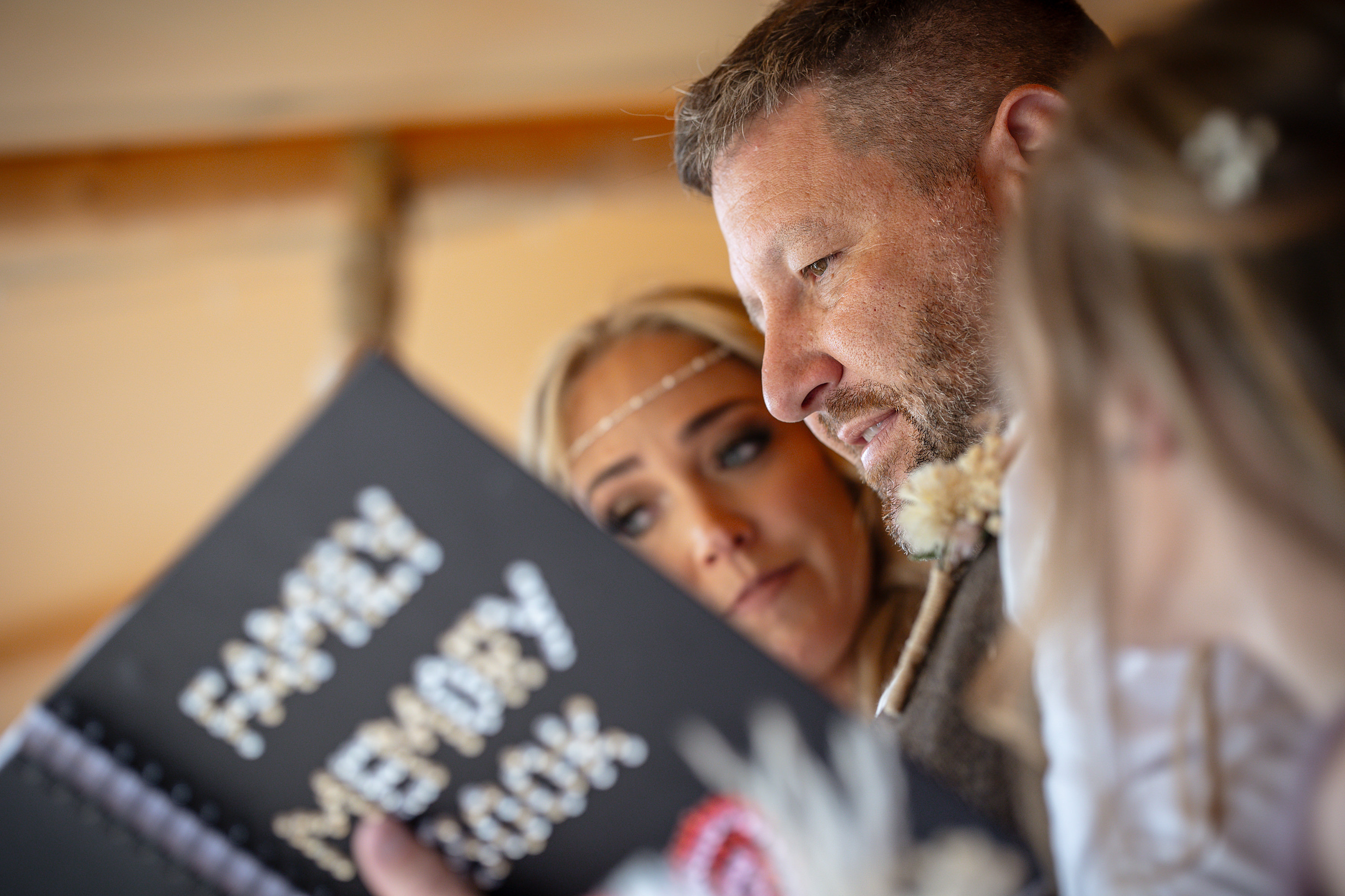 The bride and groom look through their family memory book 