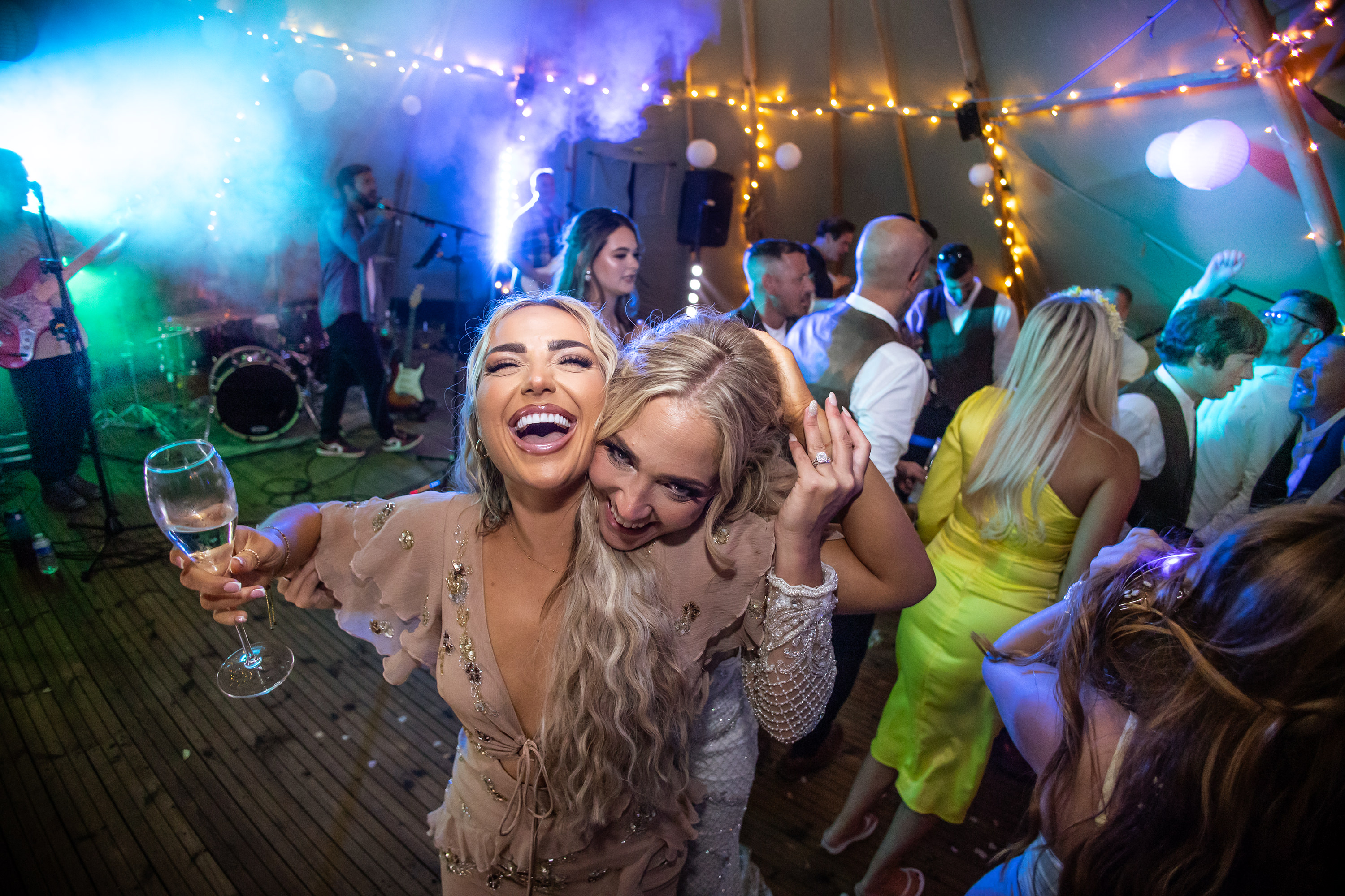 The bride and her friend having a drink on the dance floor