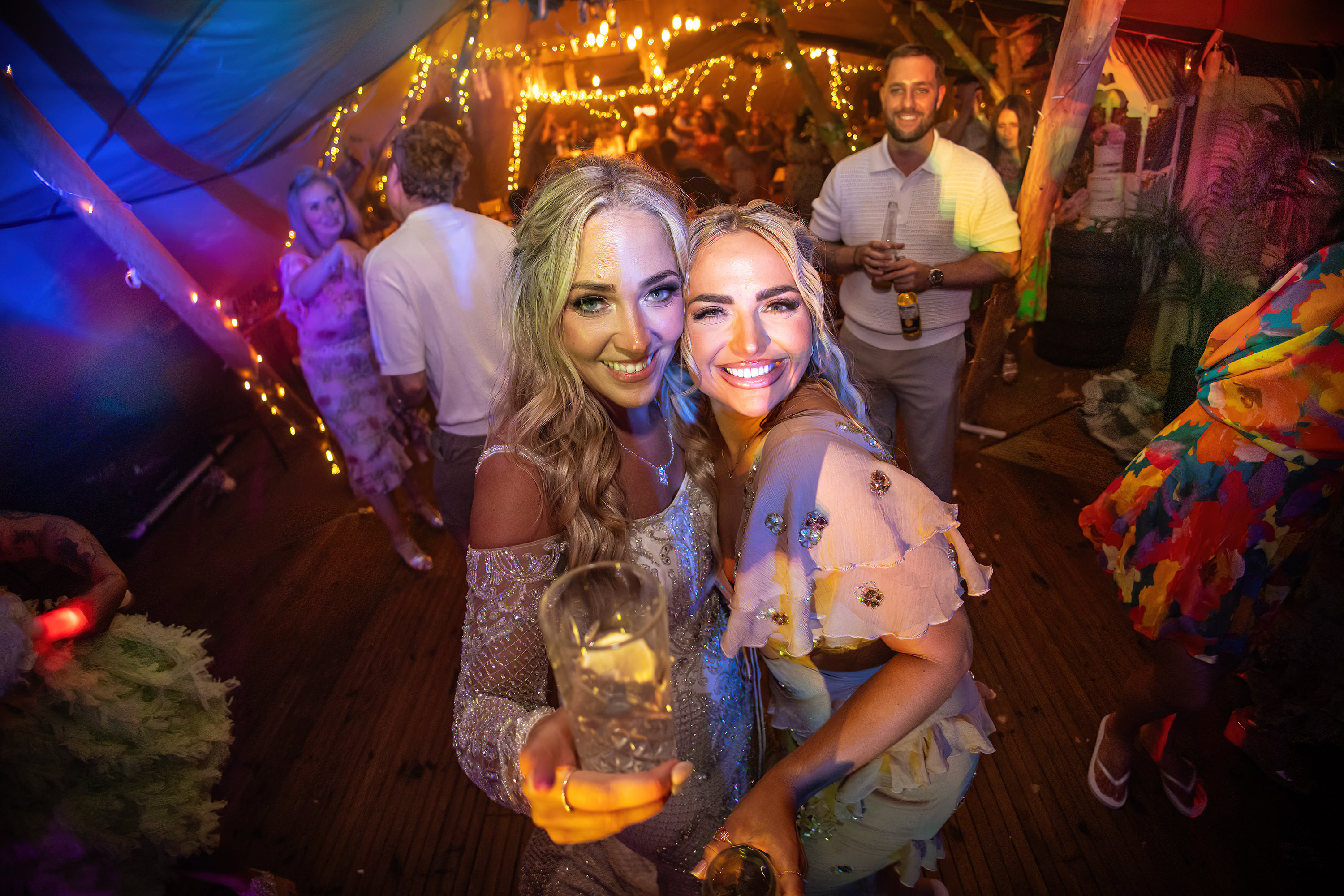 The bride and her friend having a drink on the dance floor