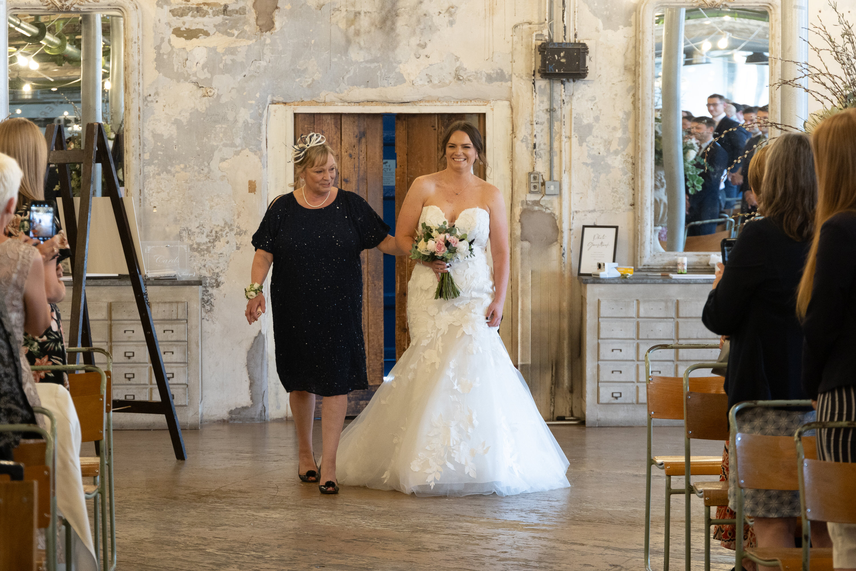 Sarah walks down the aisle with her mother 