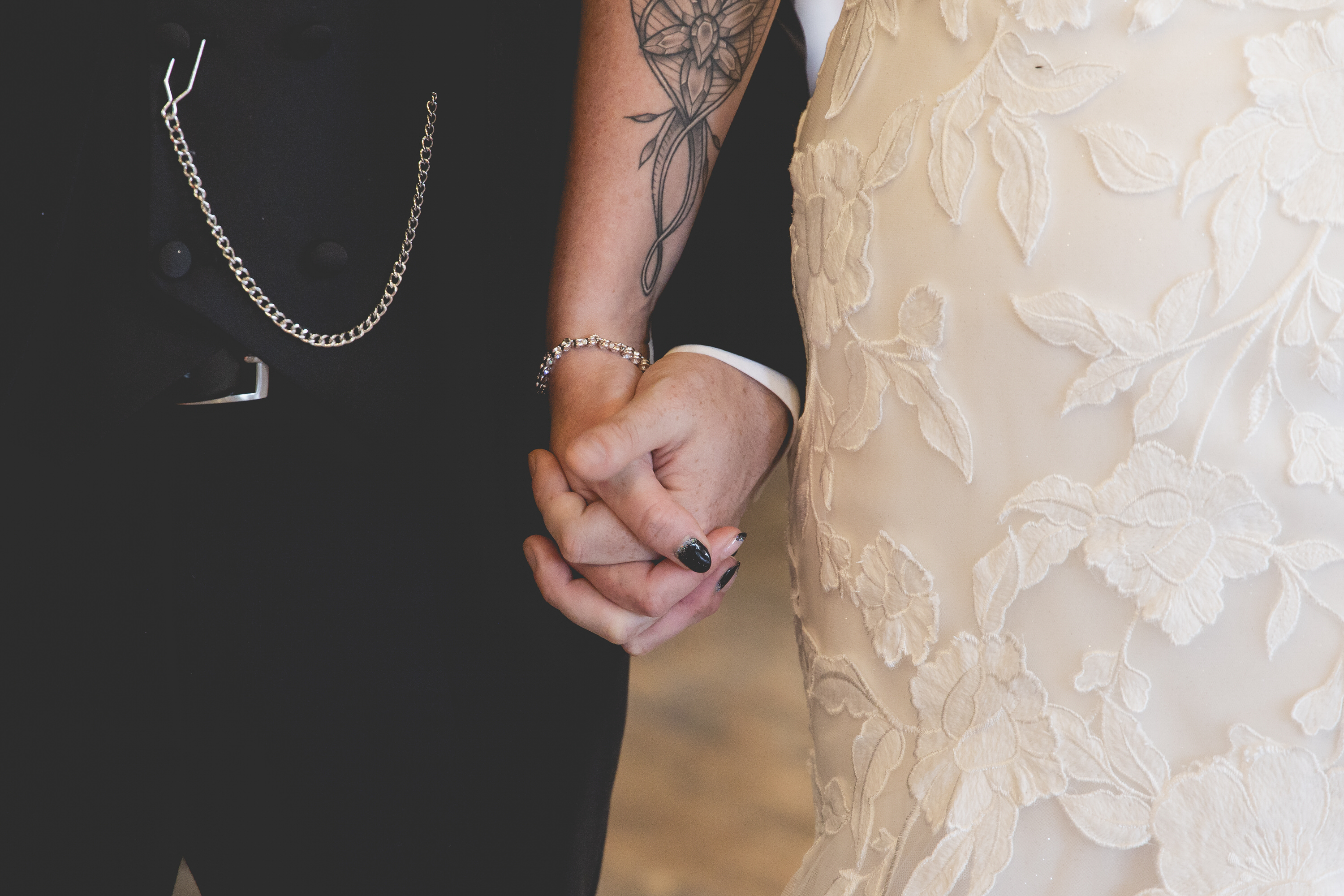 the bride and groom hold hands