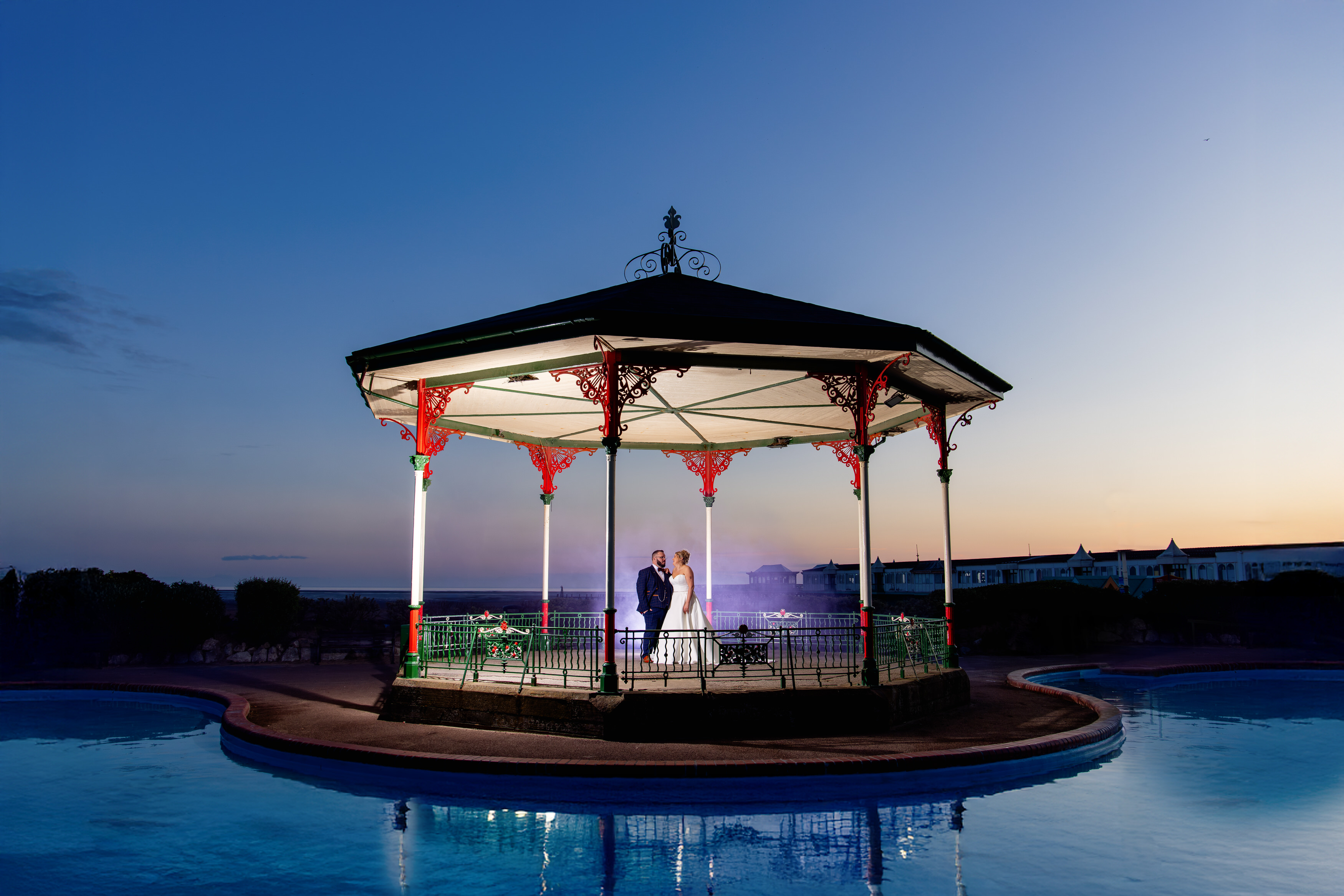 The bride and groom have their wedding photos under the bandstand 