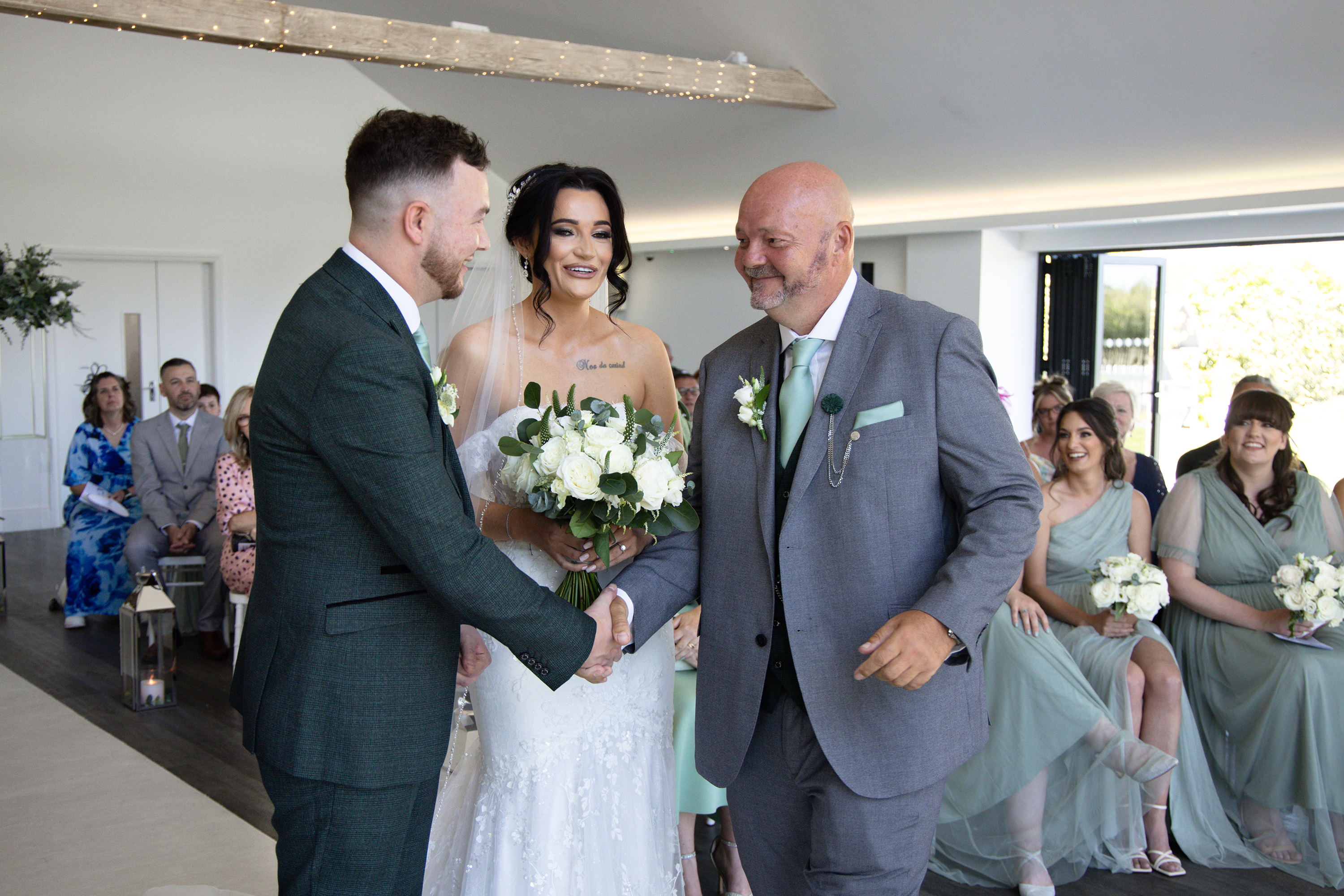 The father of the bride shakes Nathan's hand 