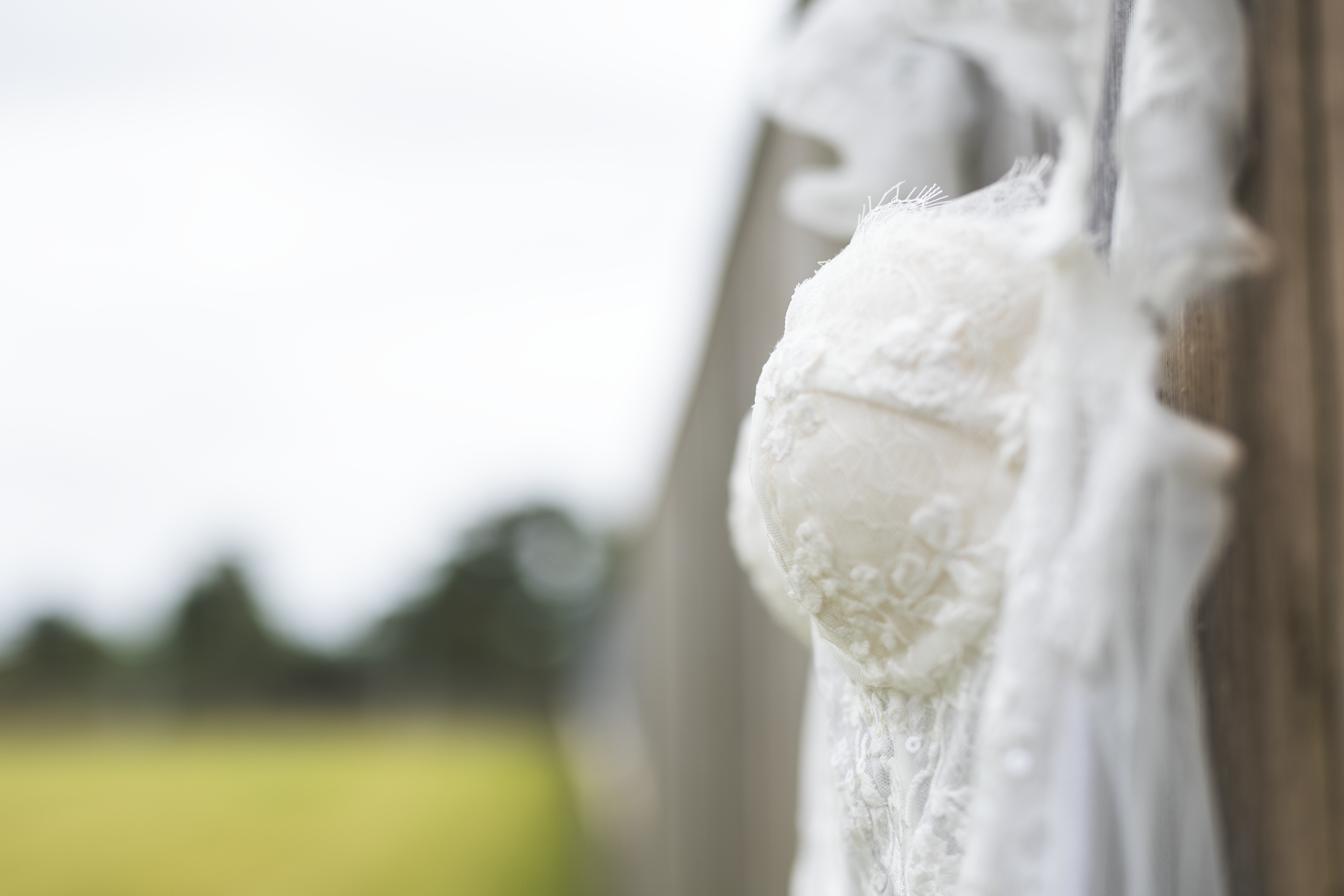The bride's wedding dress hanging on the fence 