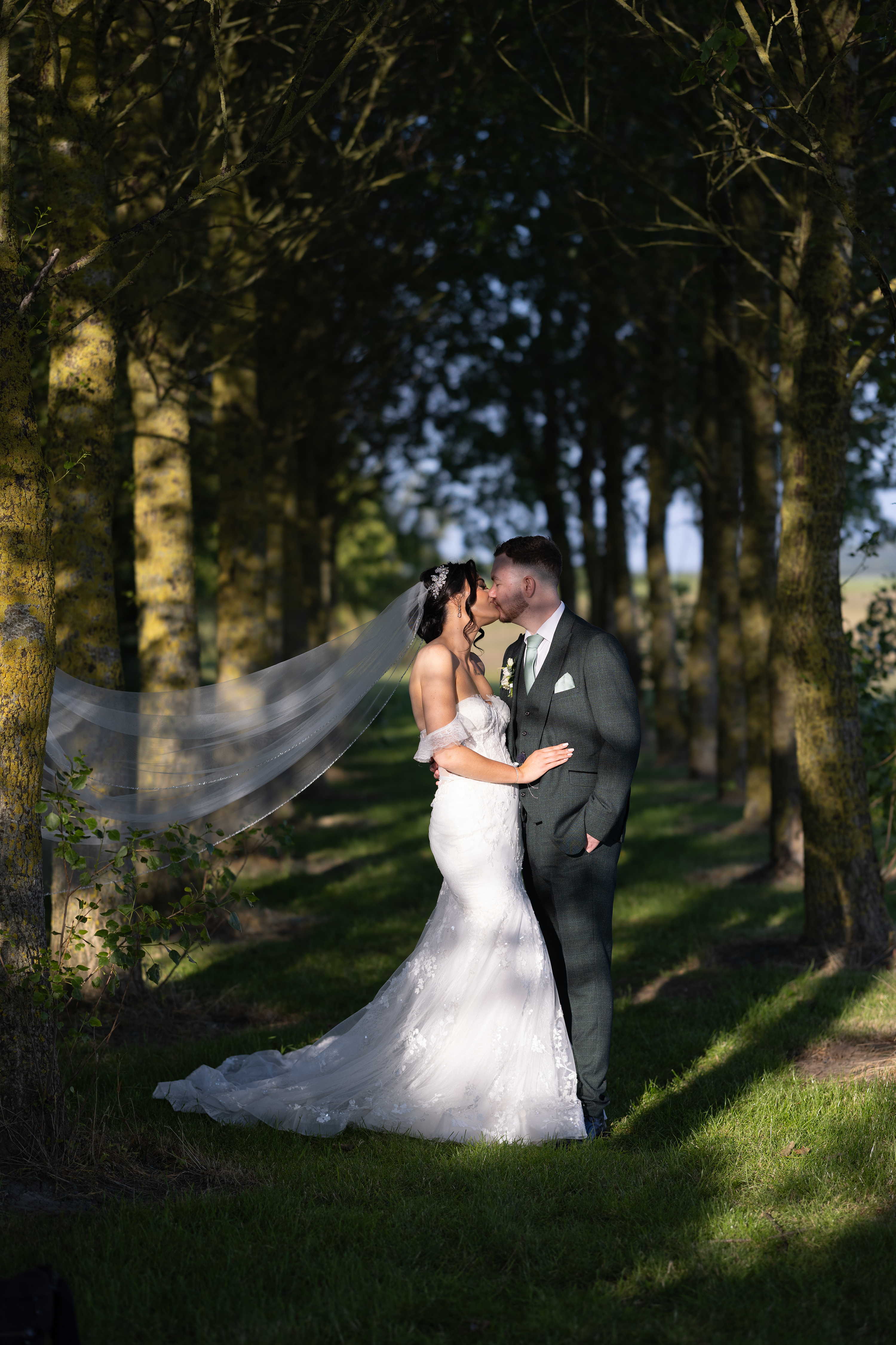 The happy couple have a kiss in the woods 