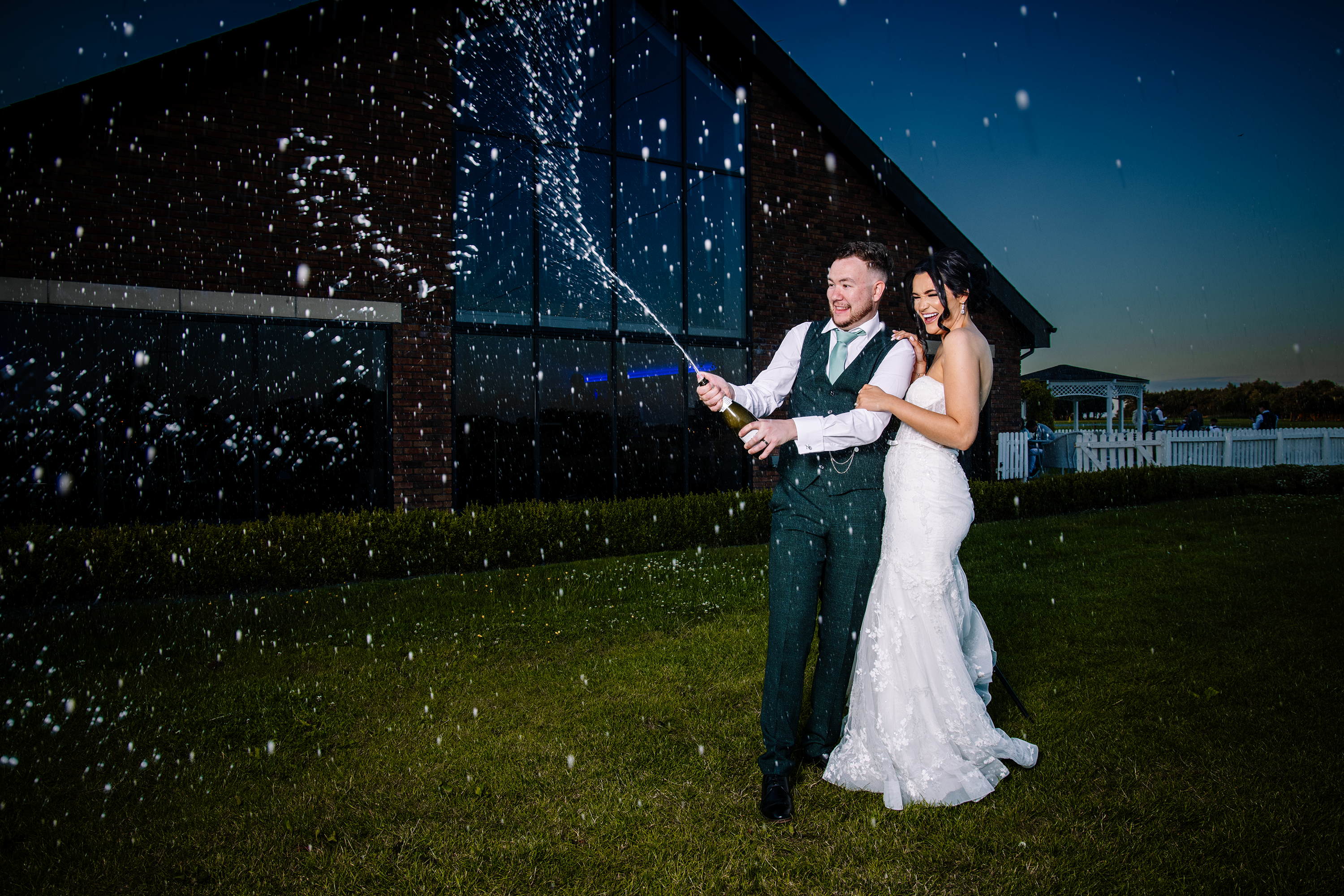 The happy couple open a bottle of champagne 