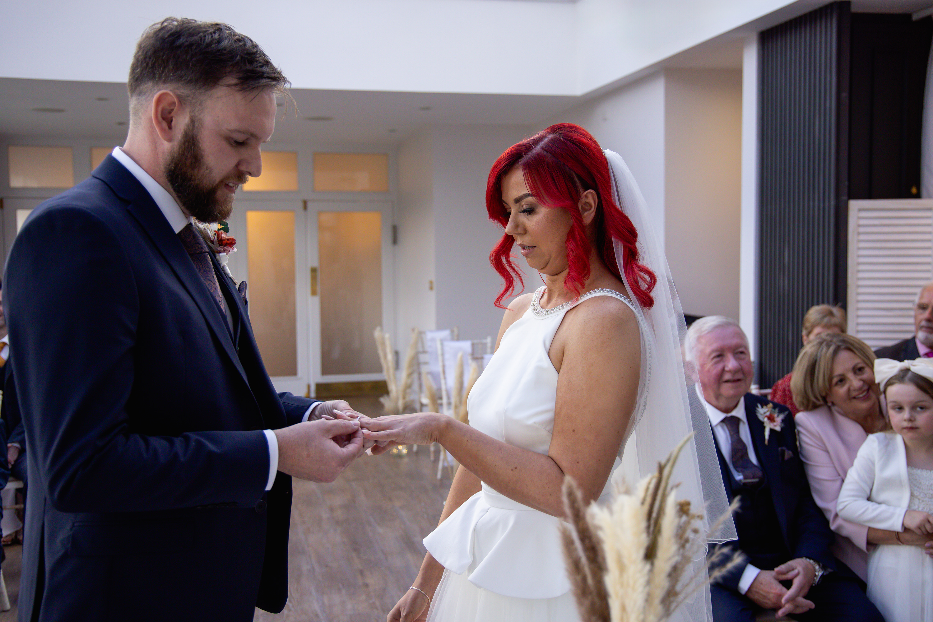 The groom puts the brides of wedding ring on 