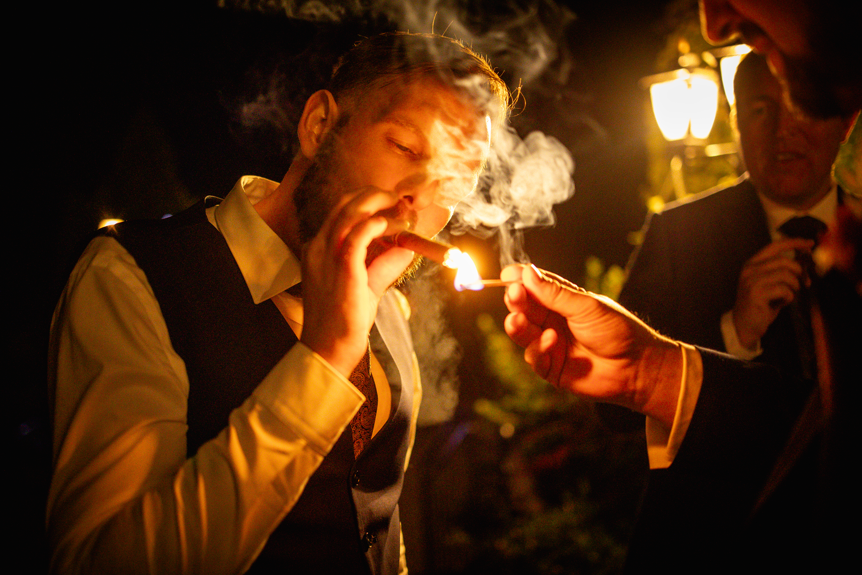 The groom enjoys a cigar with his friends 
