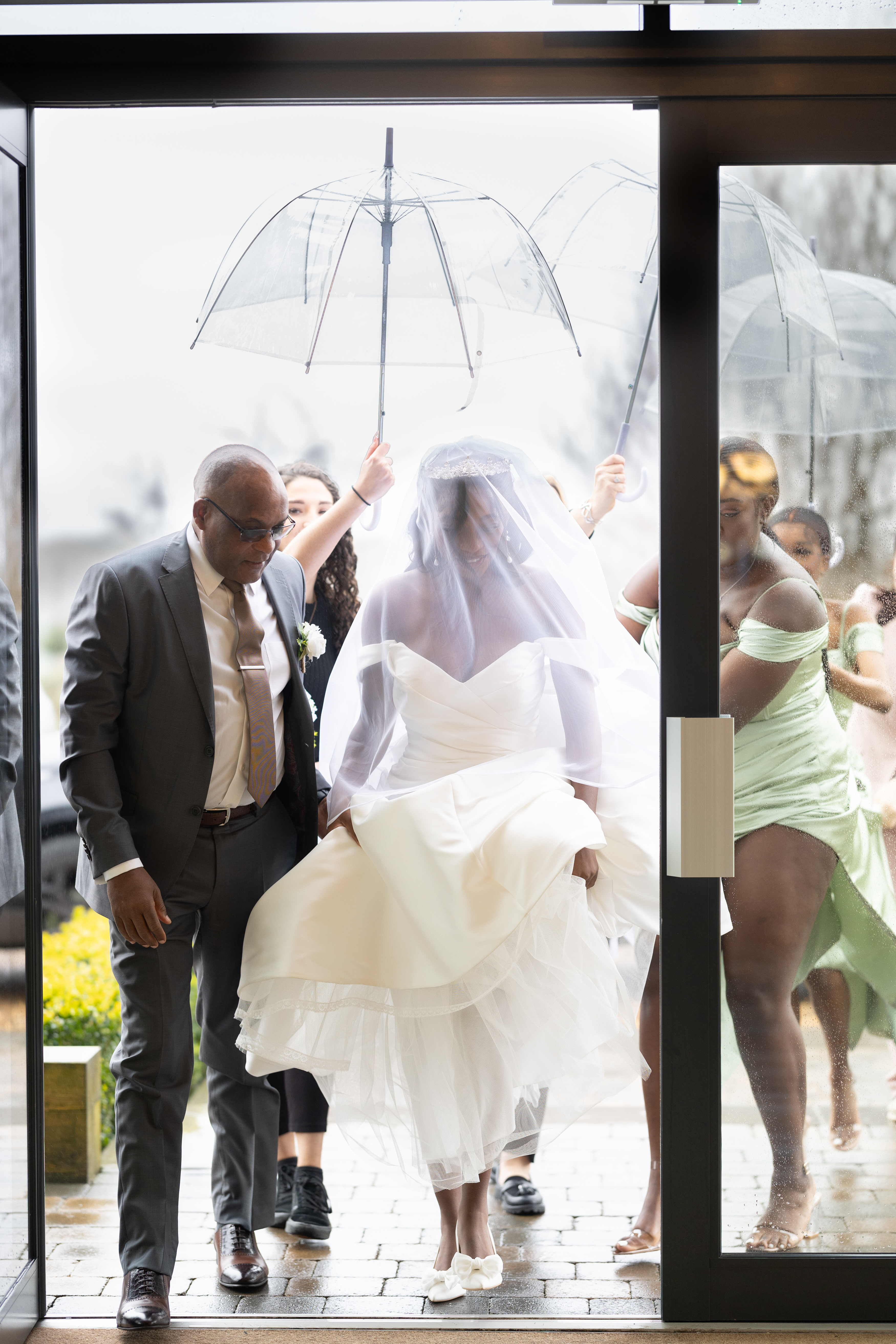 The Bride being held in to the river barn Poulton as it rains 