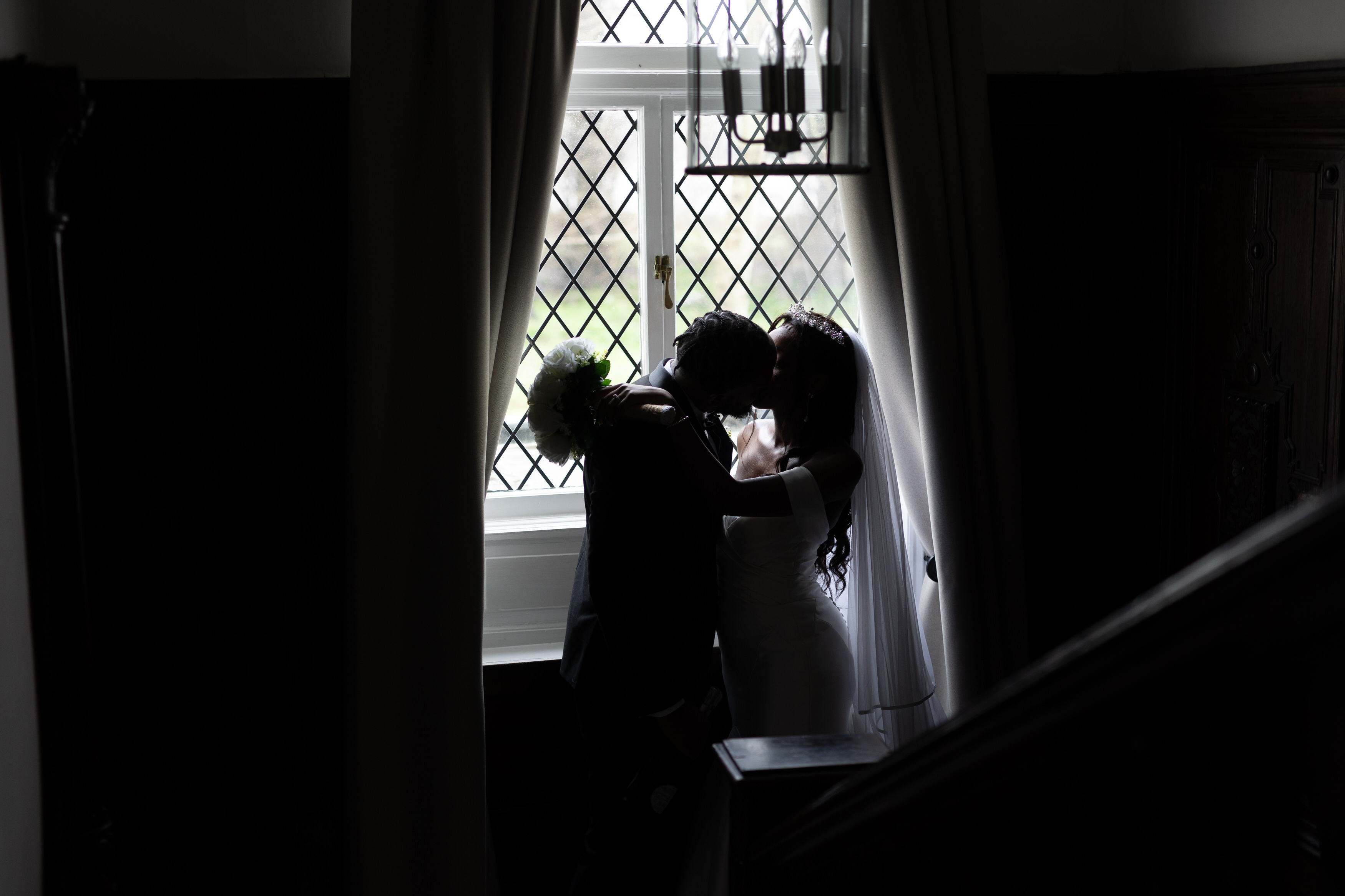 The happy couple have a kiss by the window 