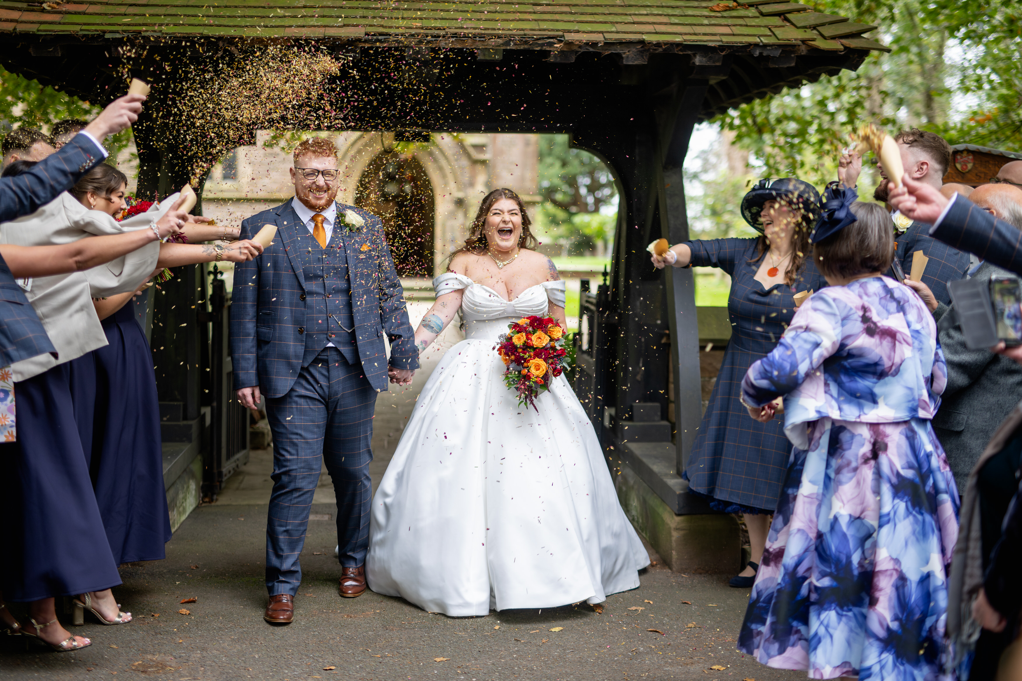The guests throw confetti at the happy couple 