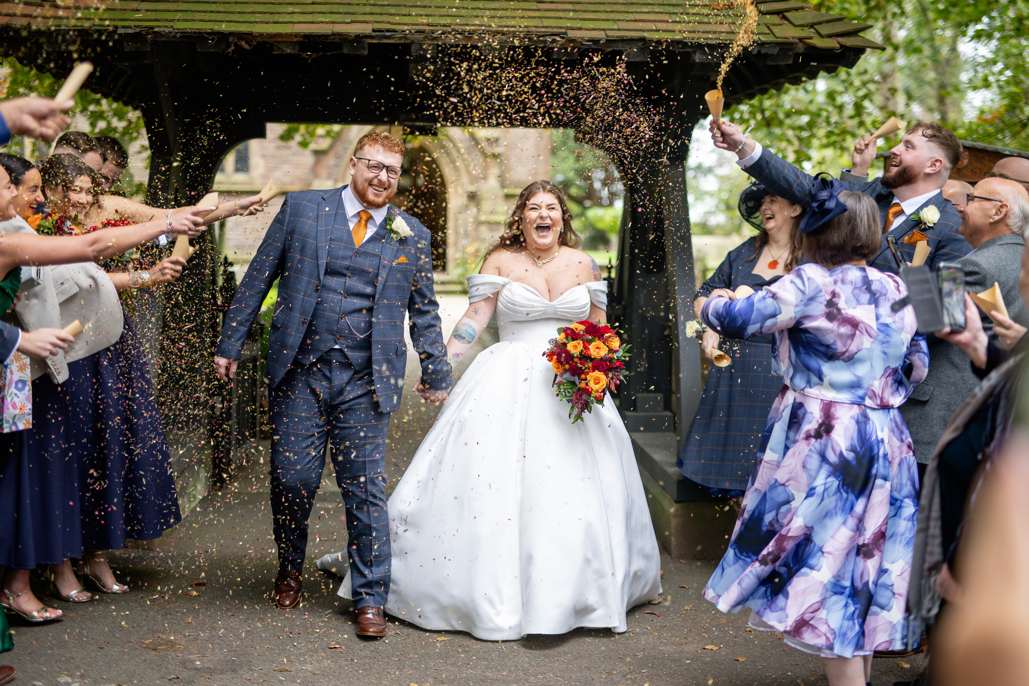 The guests throw confetti at the happy couple 