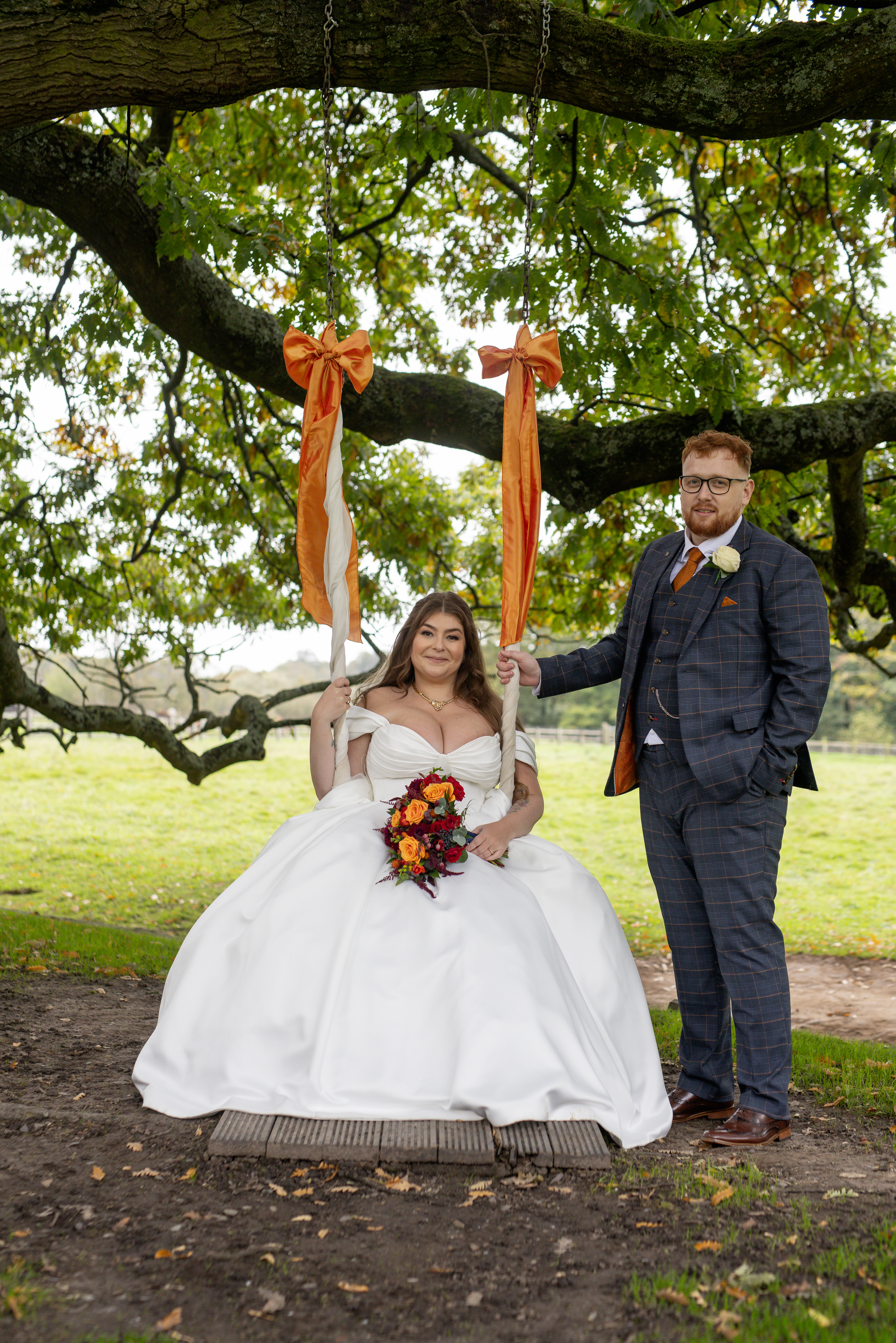 Leila and Samuel have their photo taken under the old oak tree on the swing 