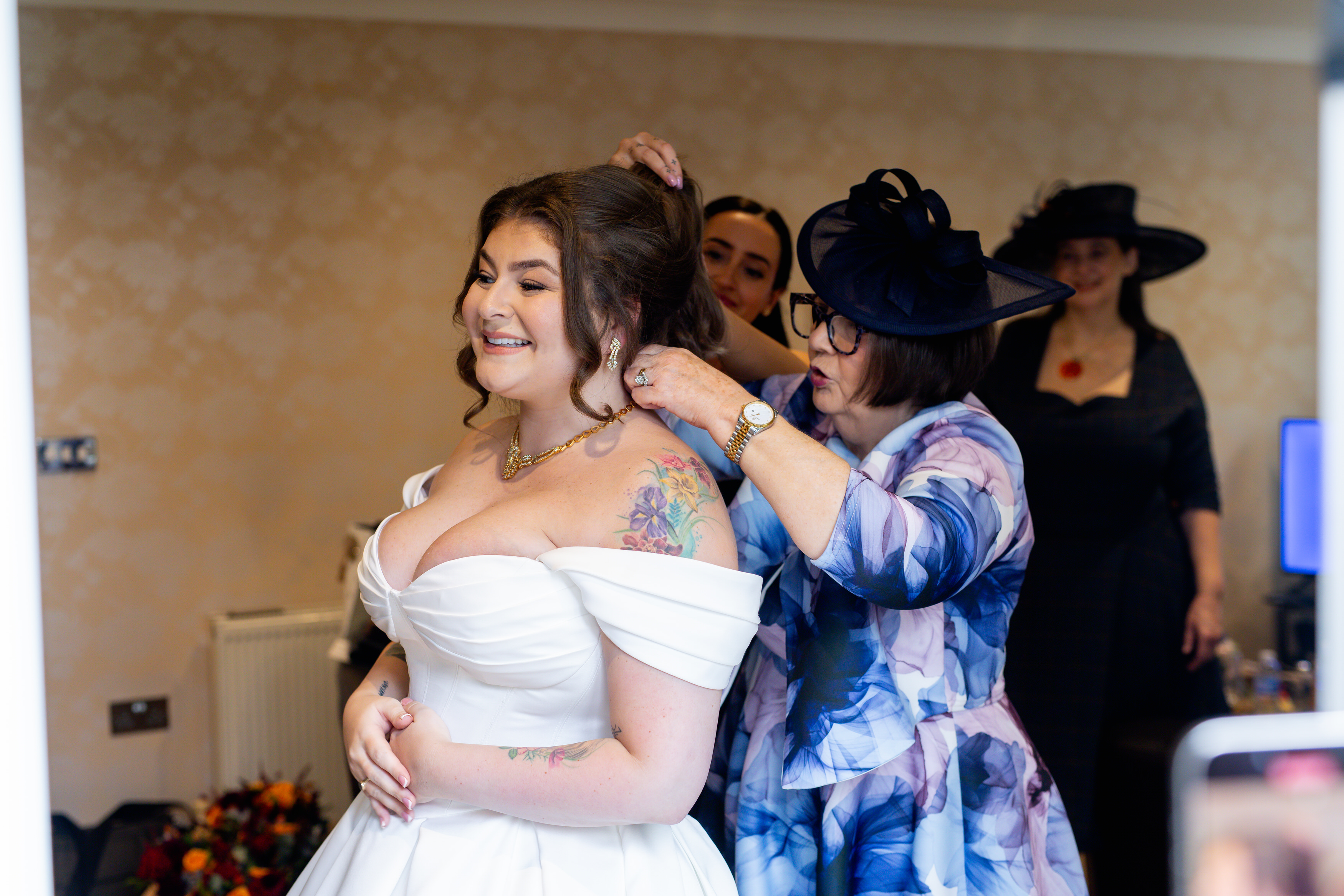 The bride's mother putting on her necklace 