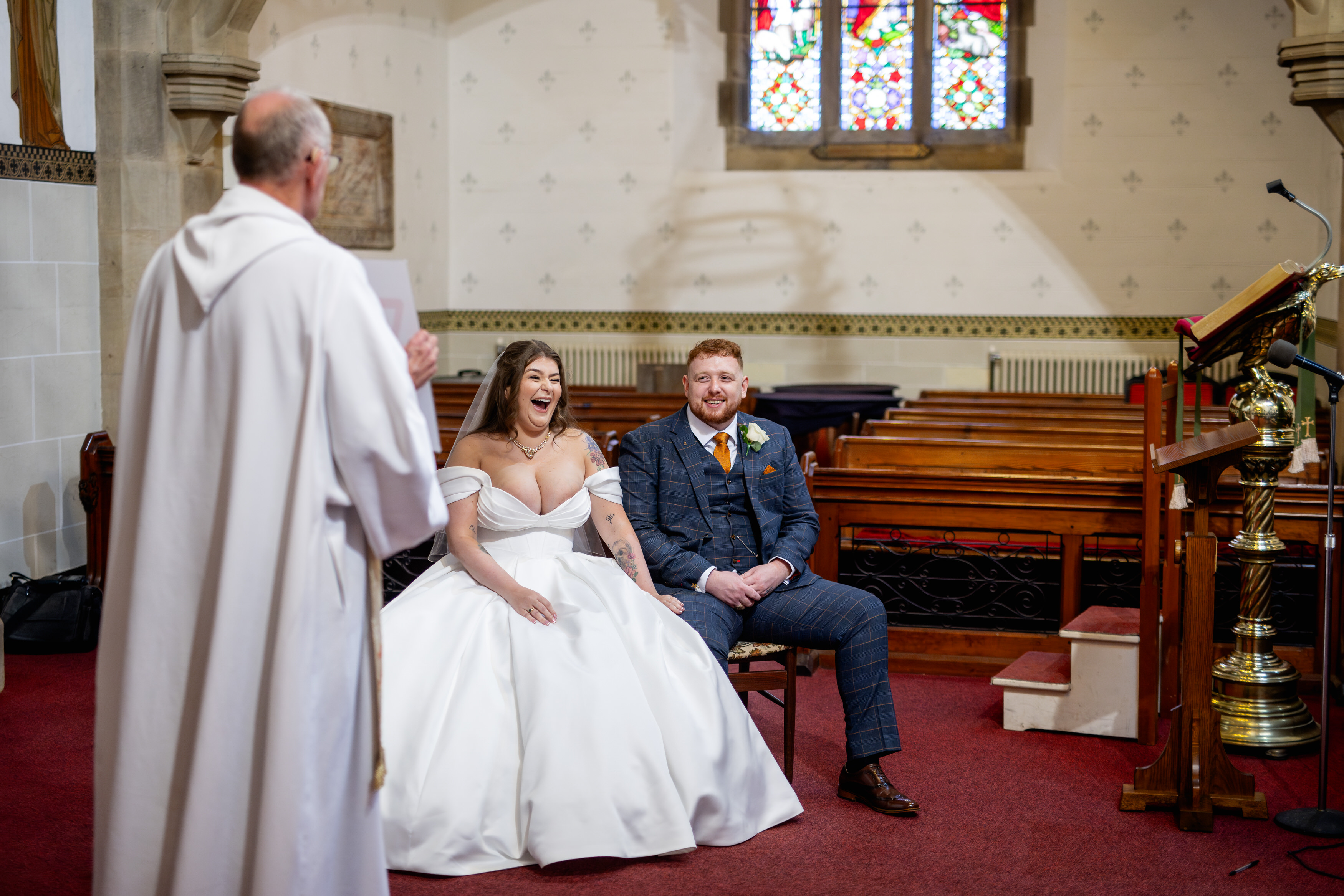 The bride and groom laughing during the sermon 