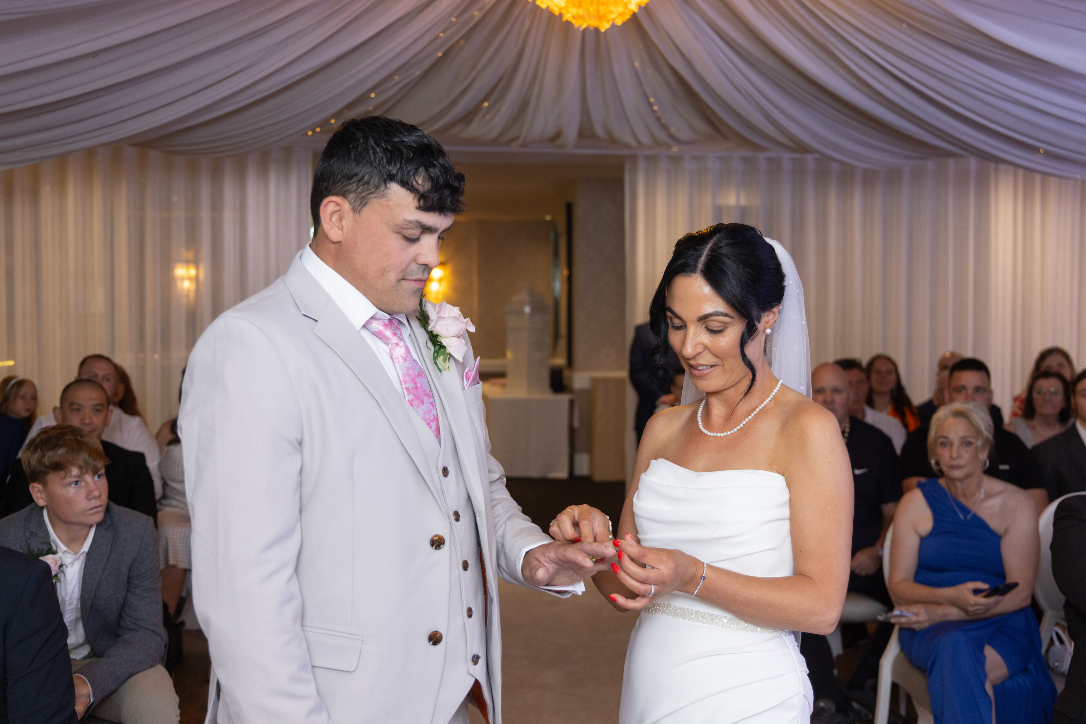 Sarah places Andrews ring on his hand 