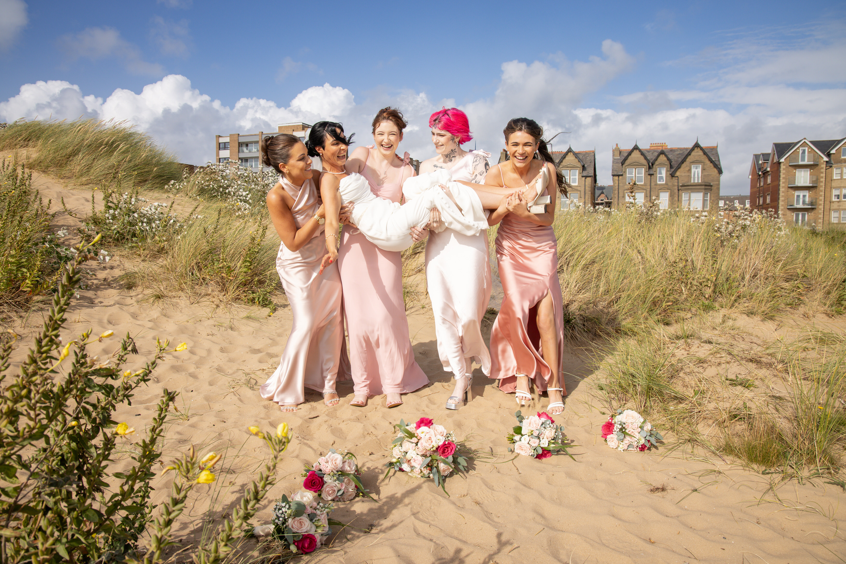 The bridesmaids throw the Bride in the air 