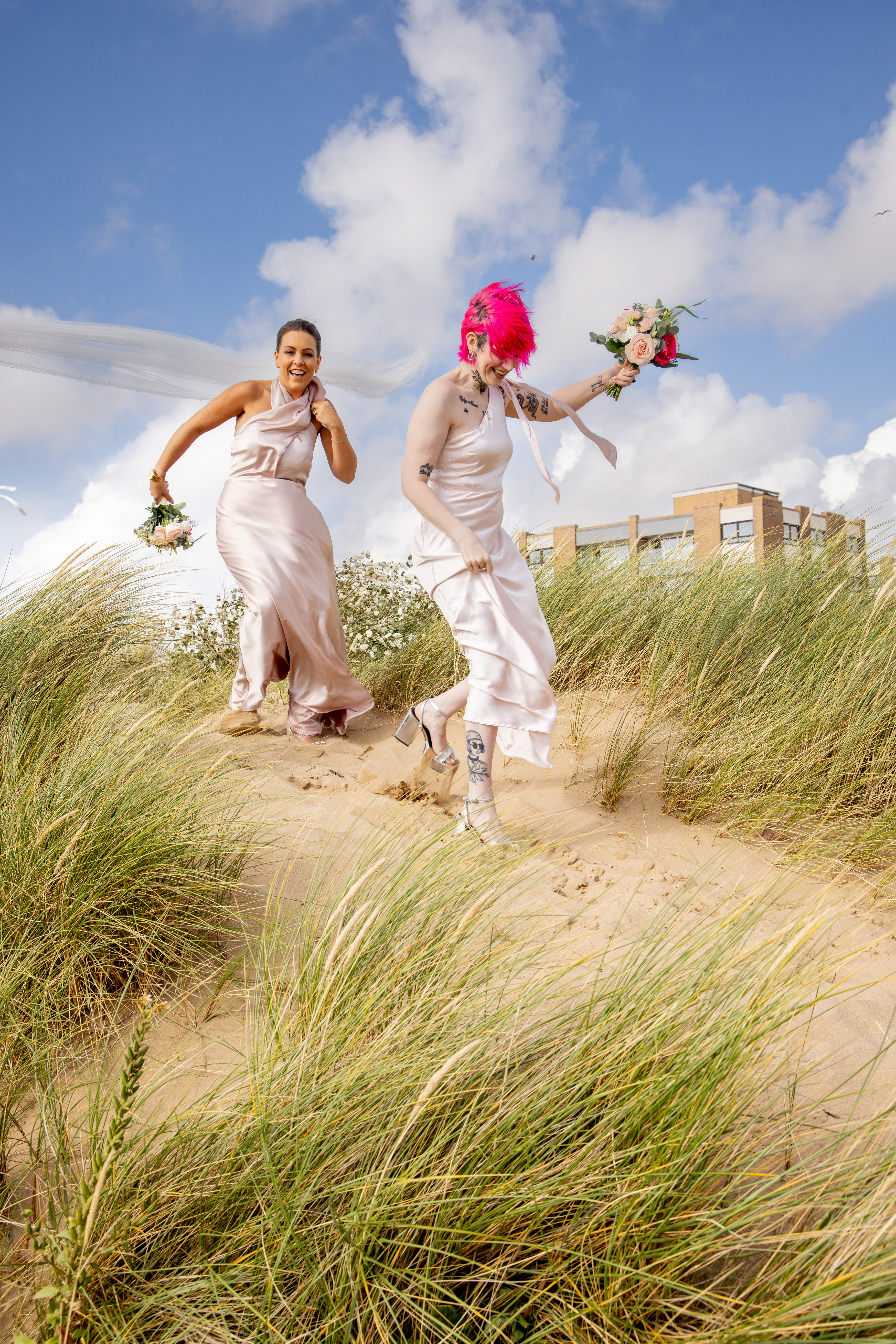 The bridesmaids make their way down the sand dune 