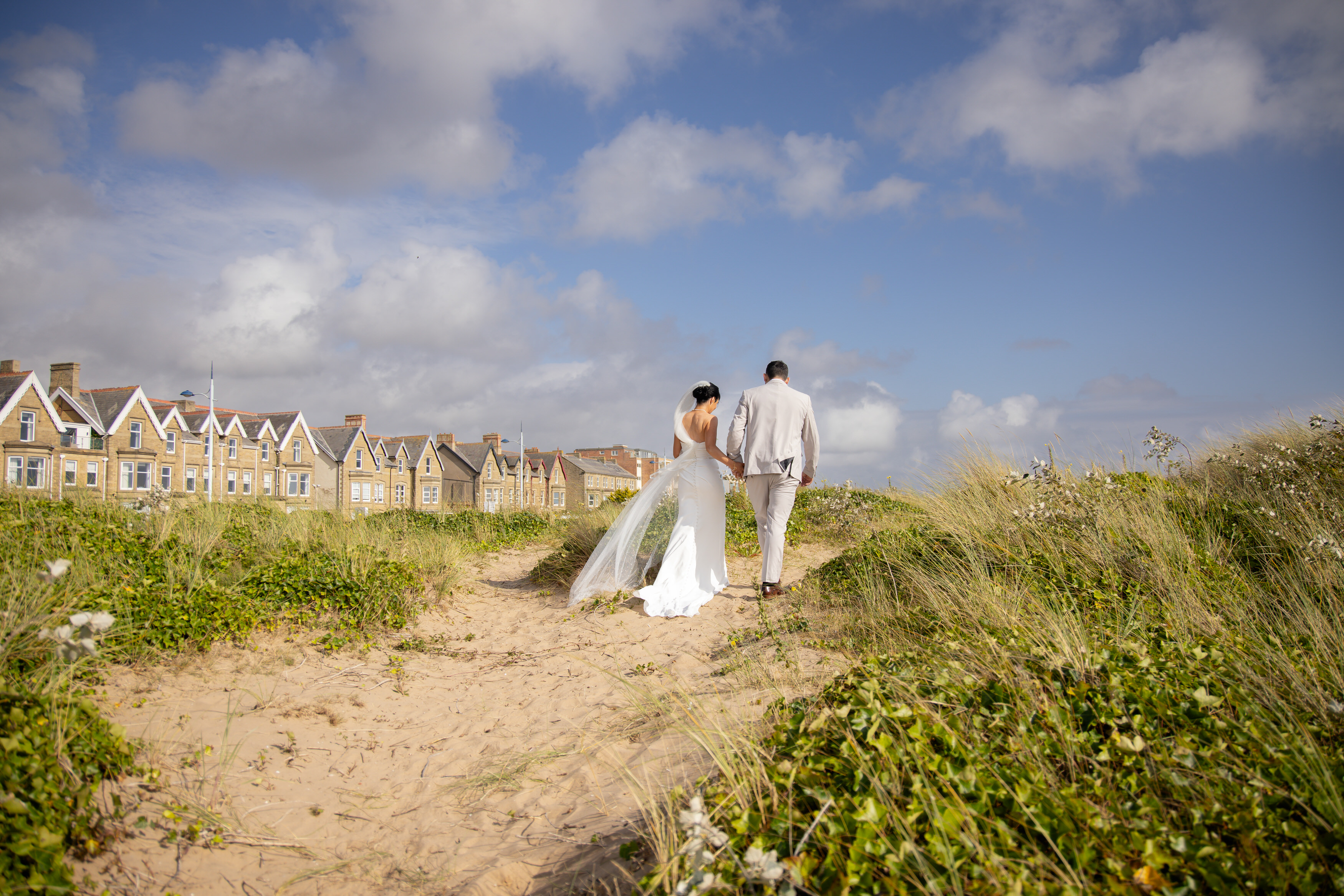 Sarah and Andrew take walk along the sand dunes hand in hand 