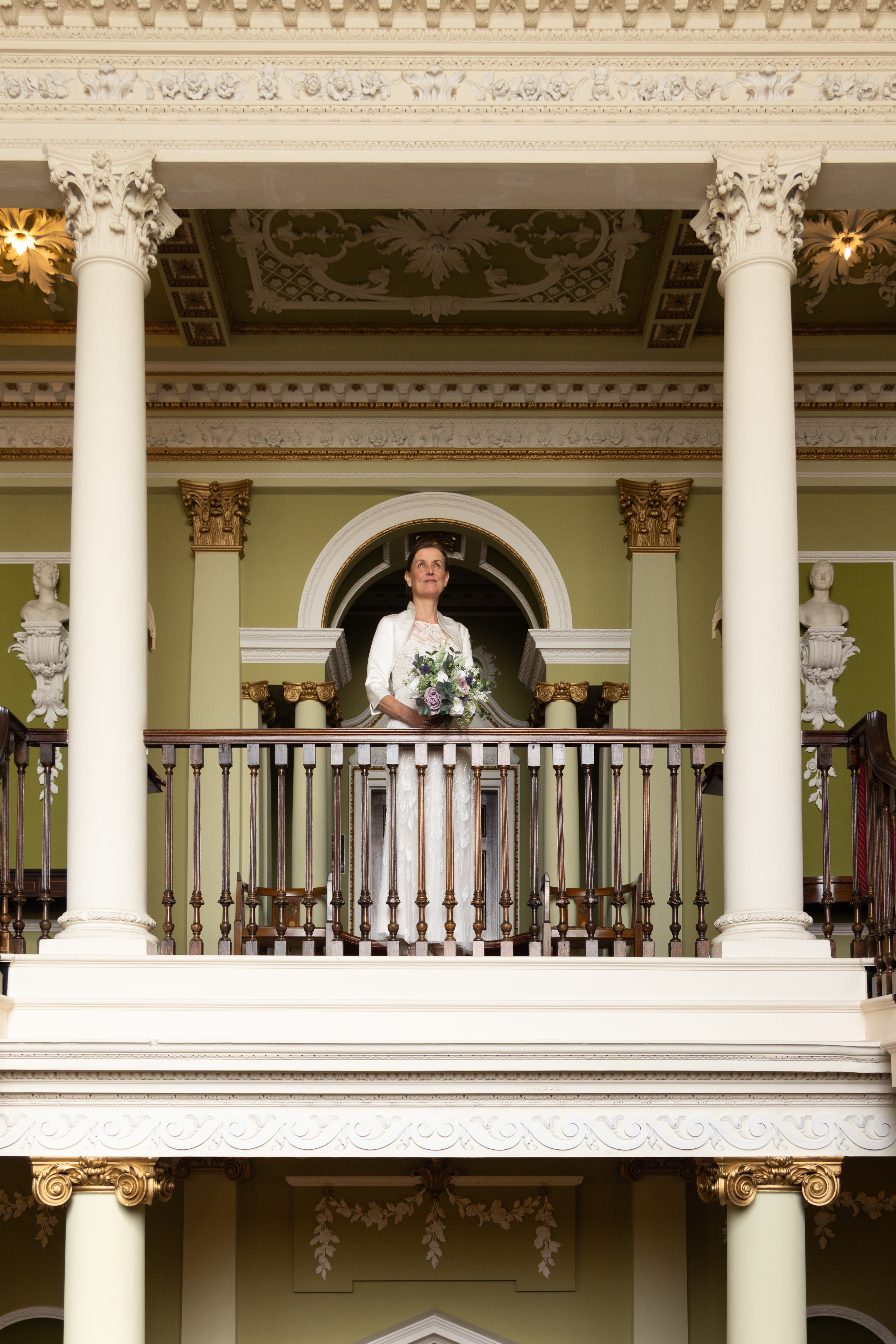 The Bride stands on the balcony for a wedding photo 