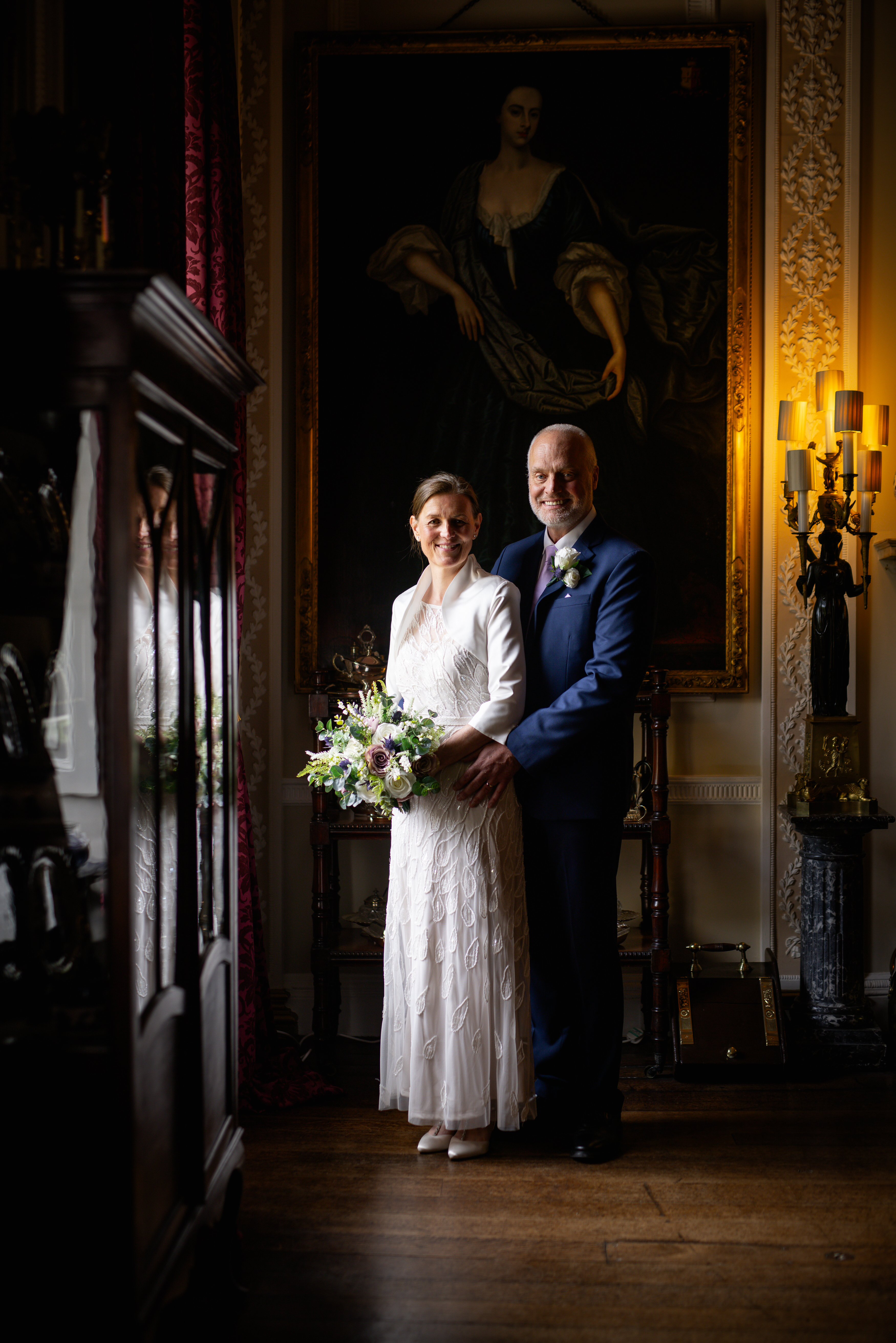 The bride and groom pose for photo in the dining room 