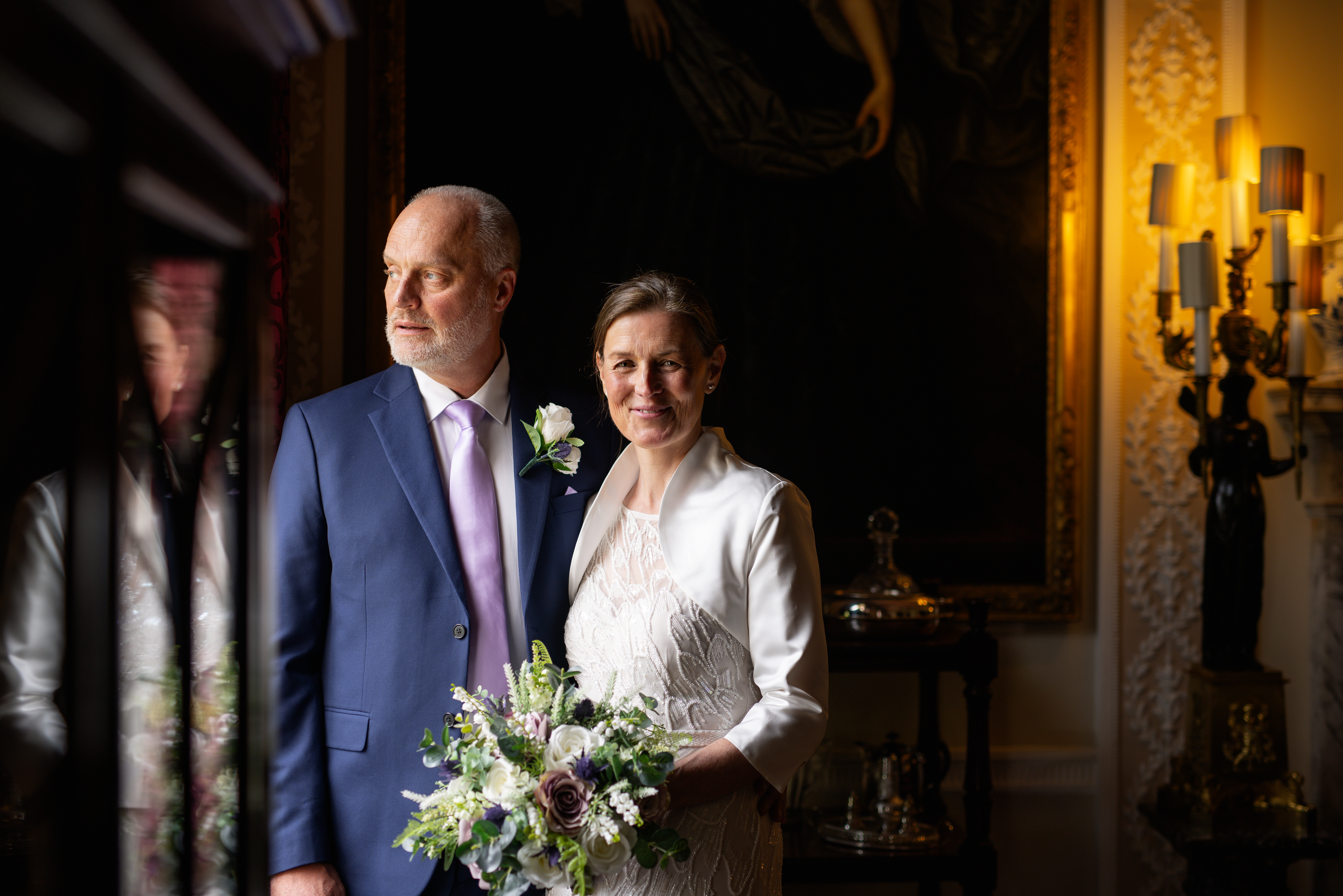The bride and groom pose for photo in the dining room 