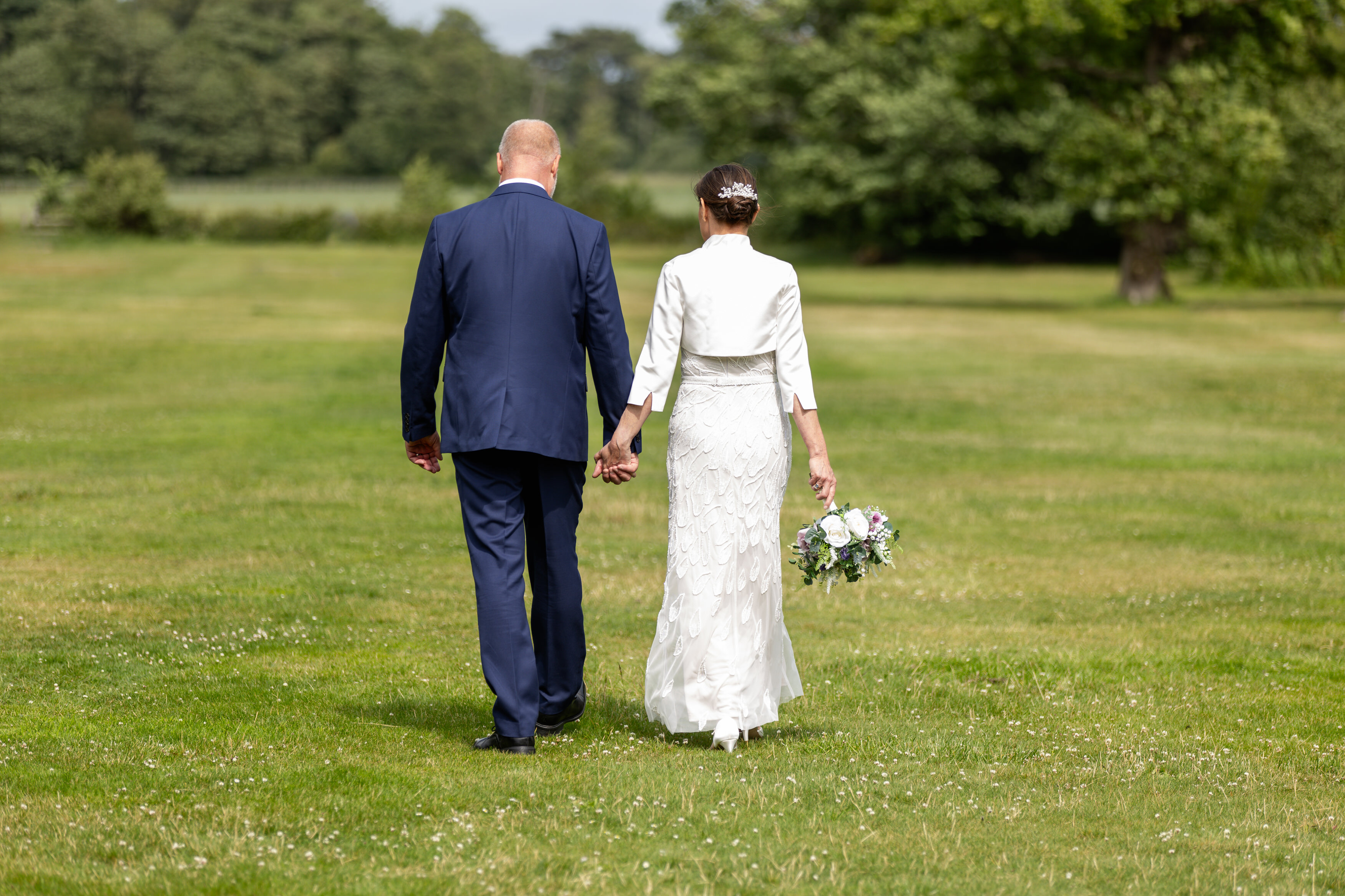 The bride and groom walk in the grounds of Lytham Hall