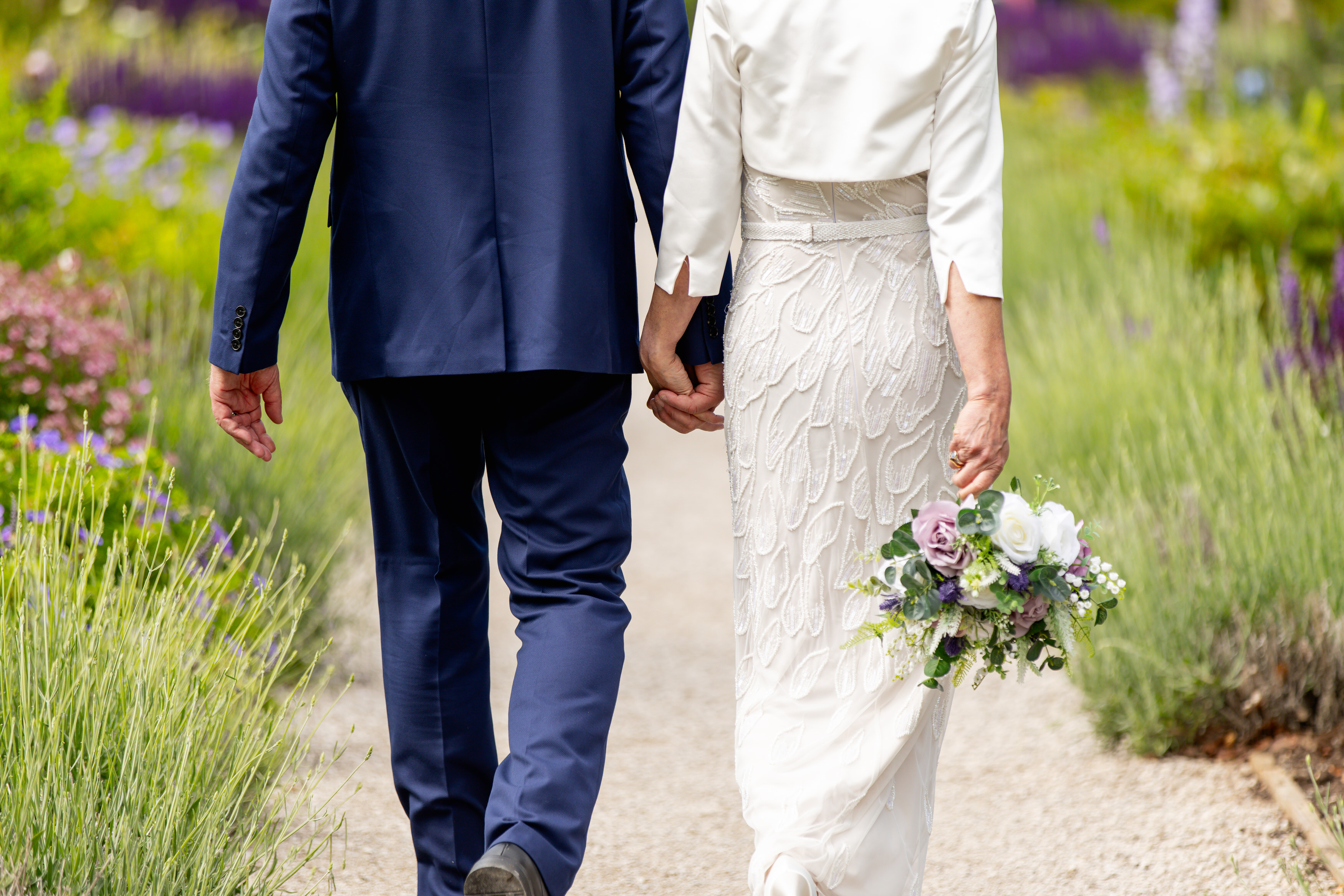 The bride and groom hold hands 