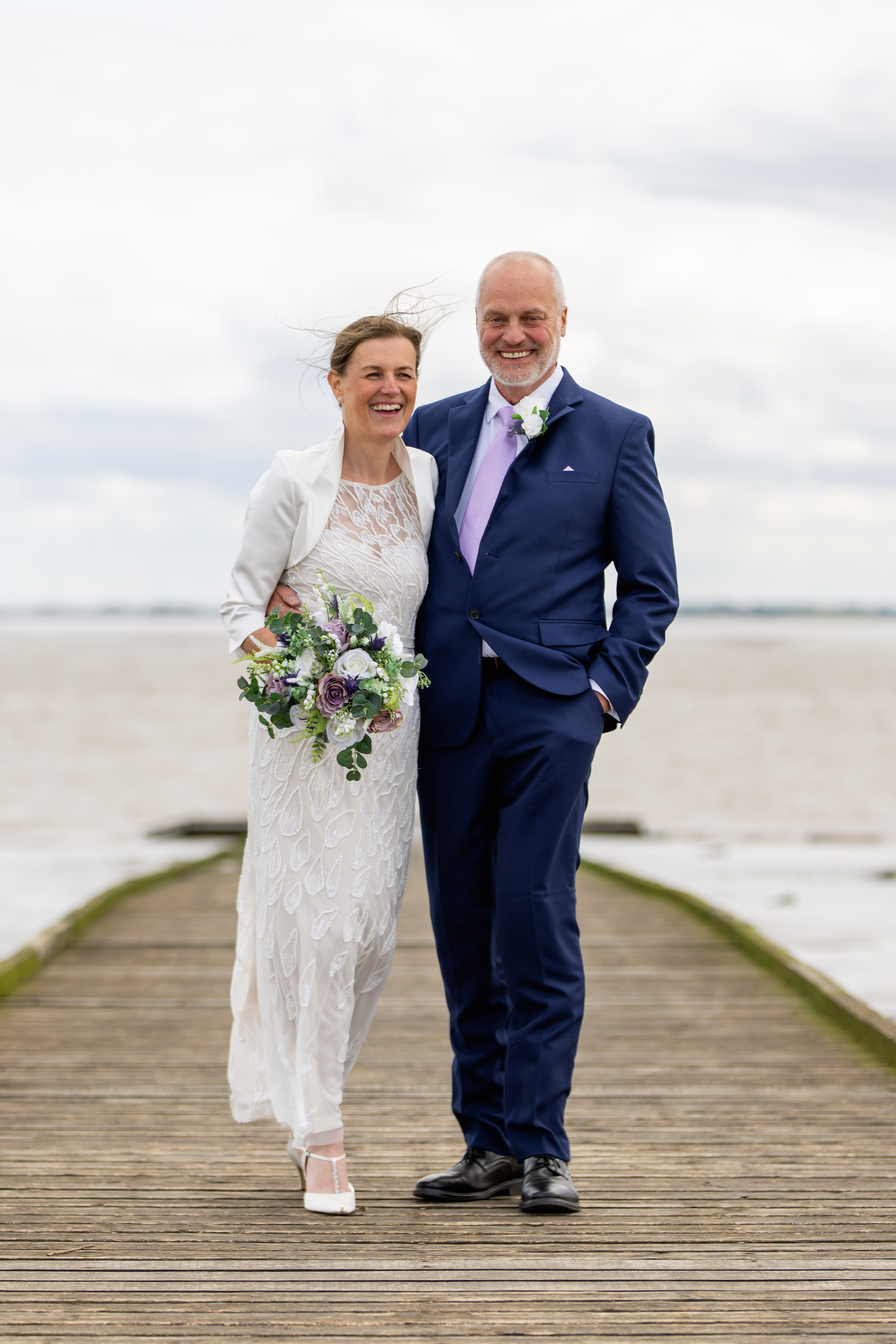 The bride and groom have a kiss on lytham jetty 
