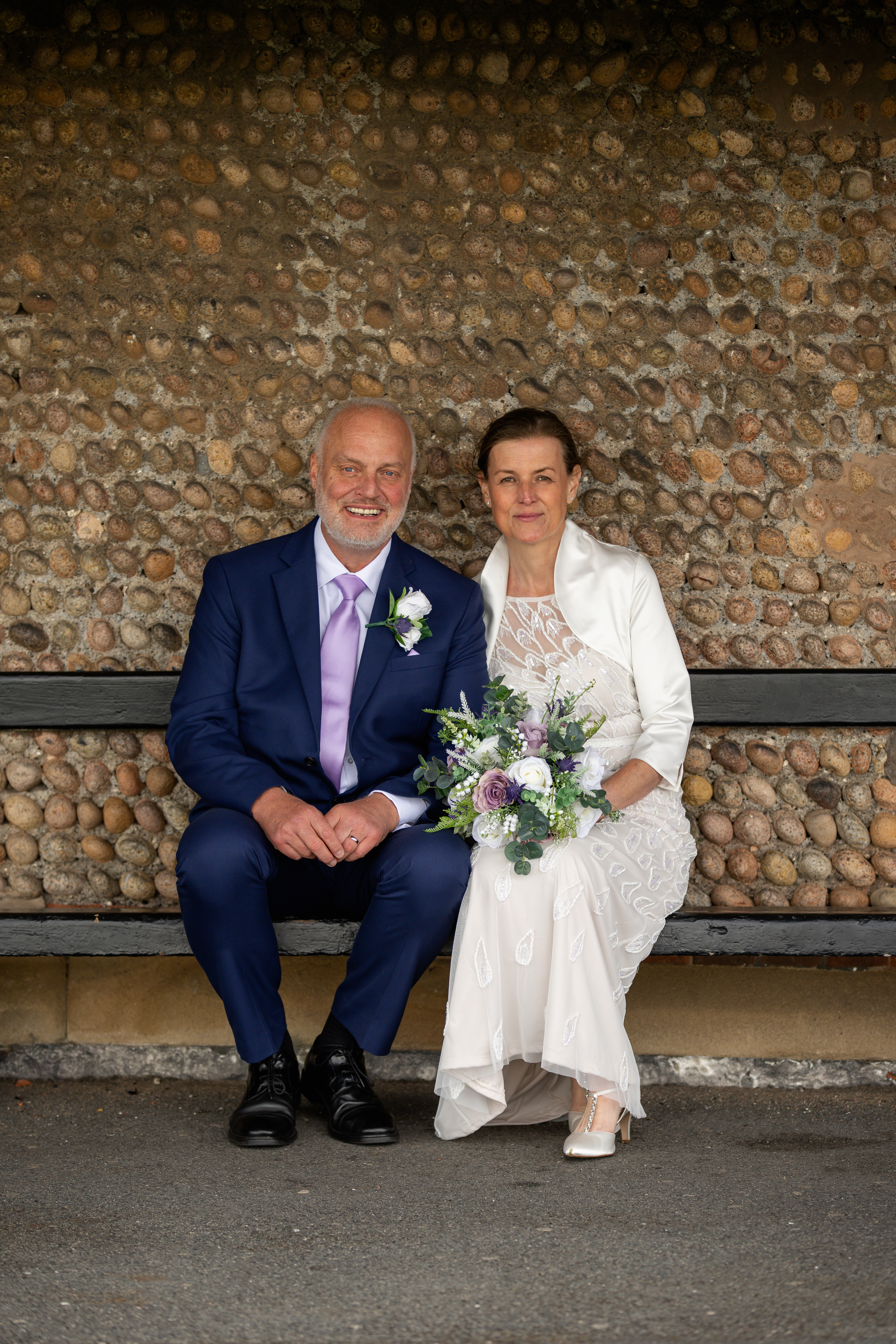 The bride and groom take a seat at the Old Boathouse 