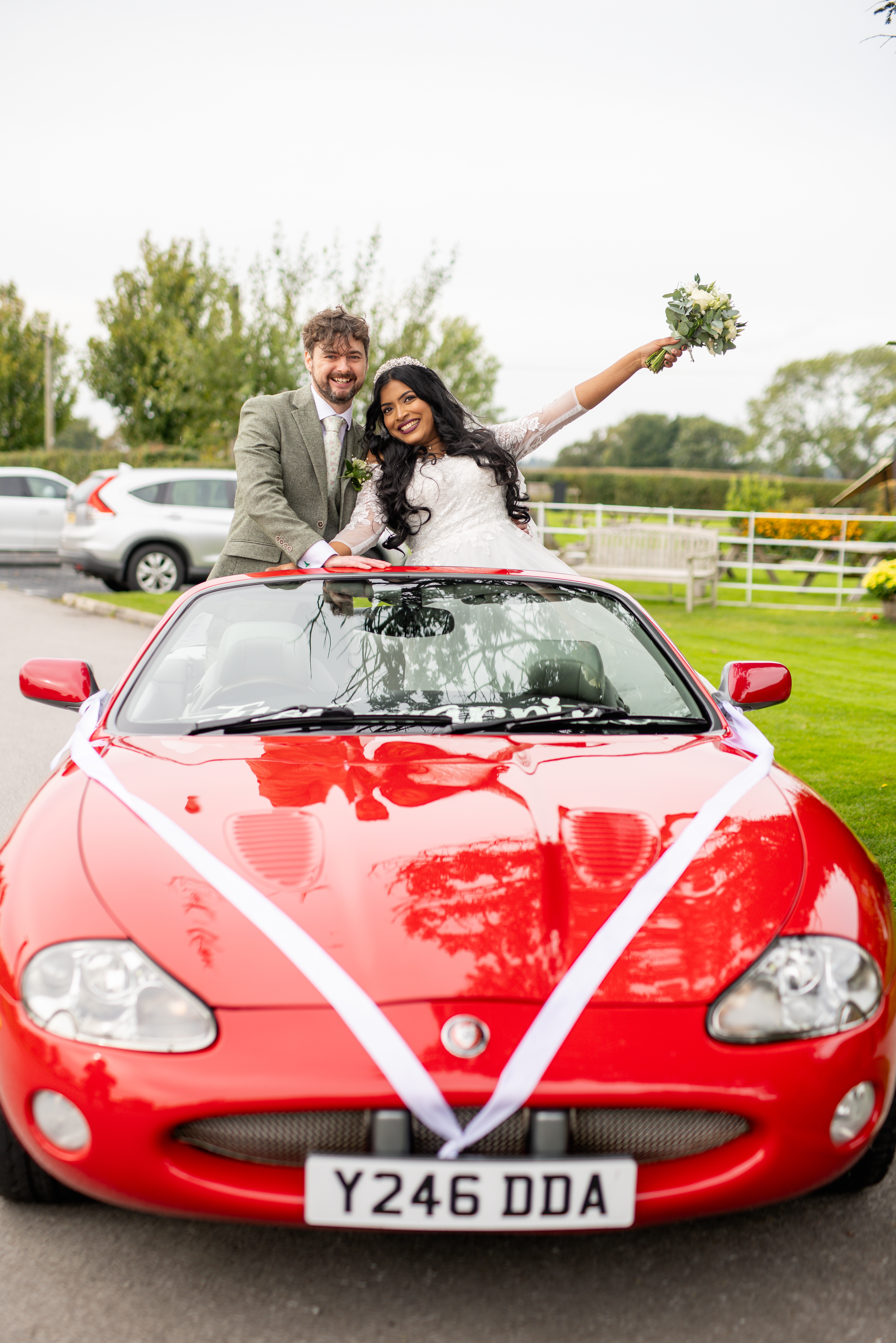 The happy couple pose for a photo in the Ferrari 