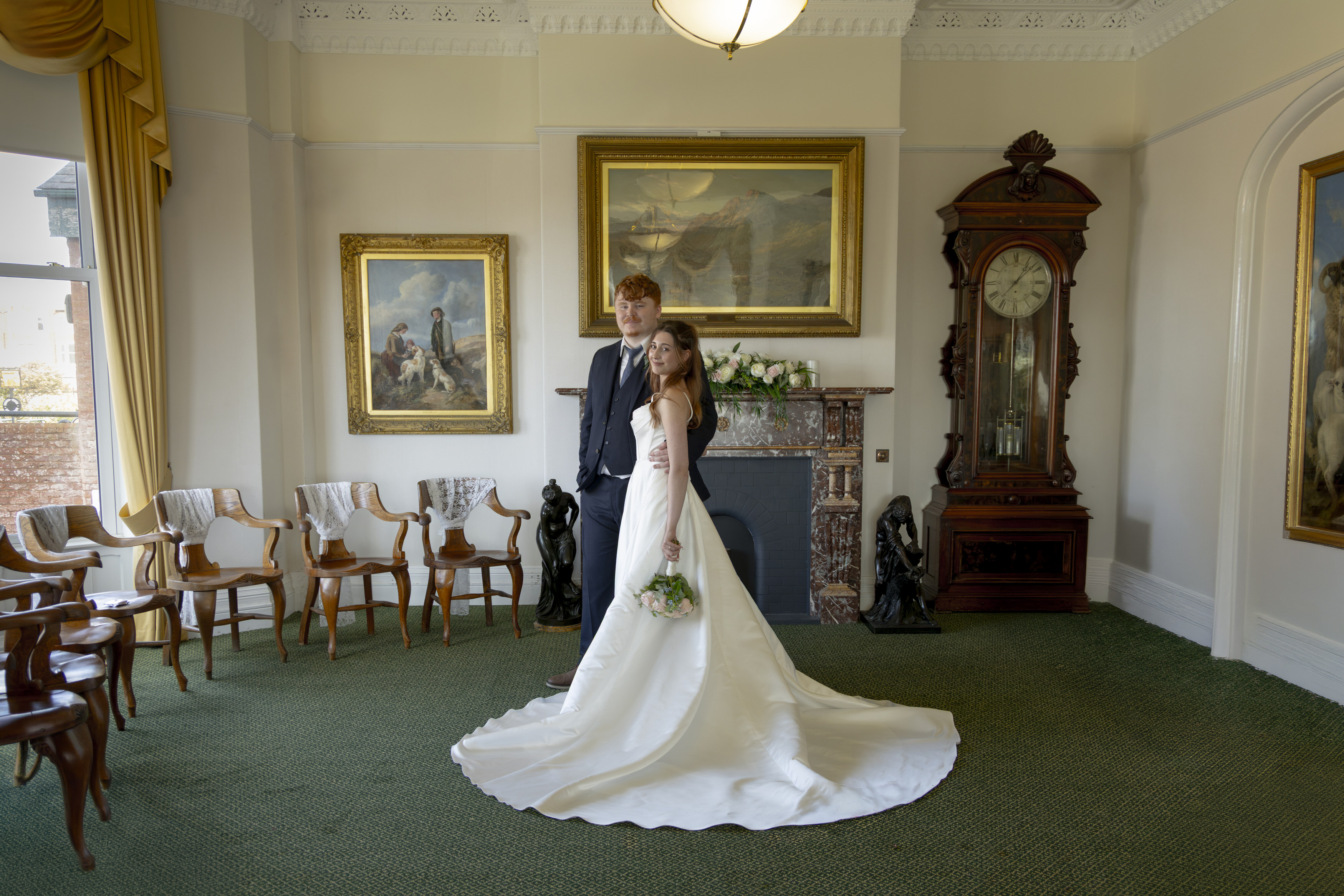 The happy couple pose for a photo in the ceremony room 