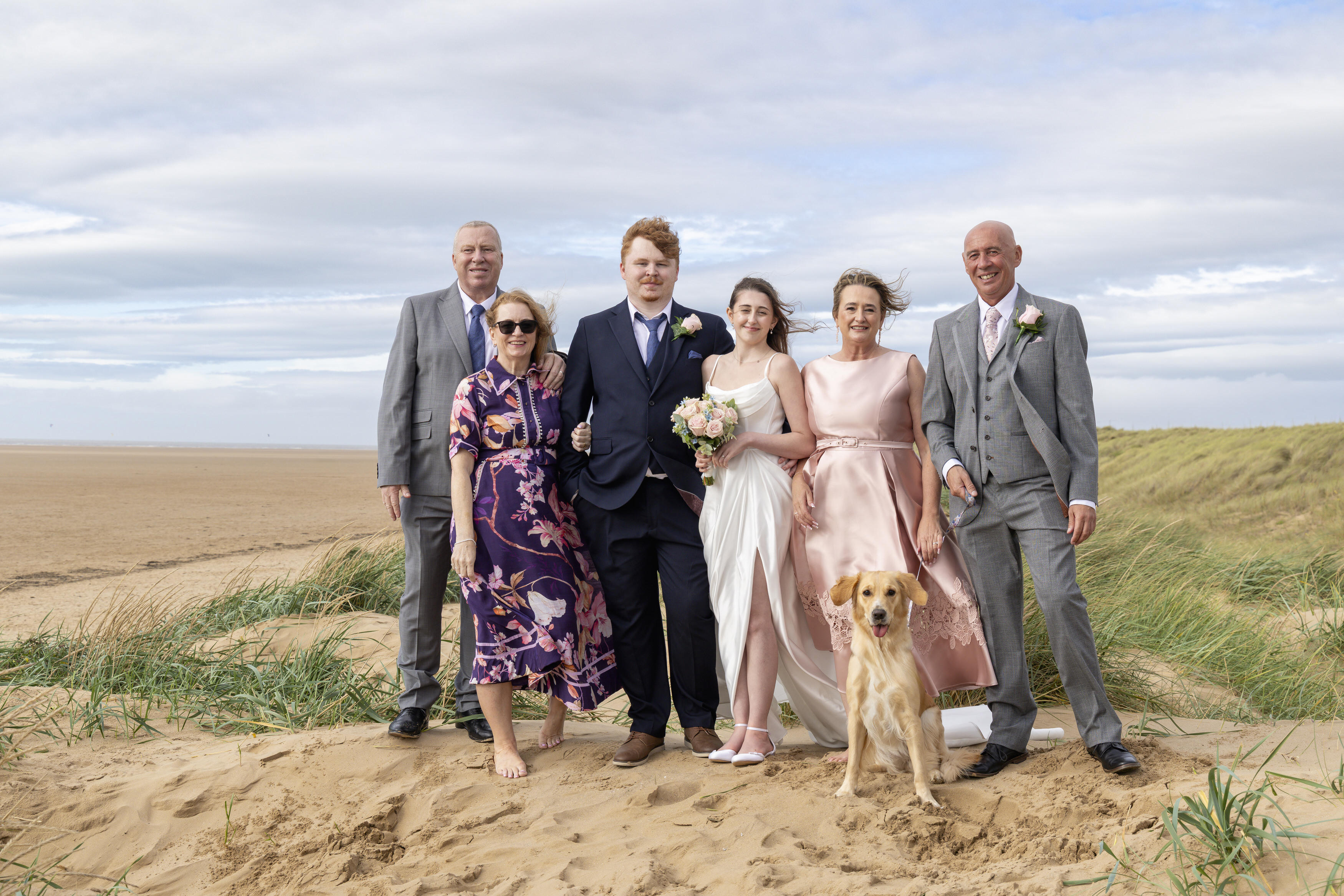 A family photo with the bride and groom and their parents 