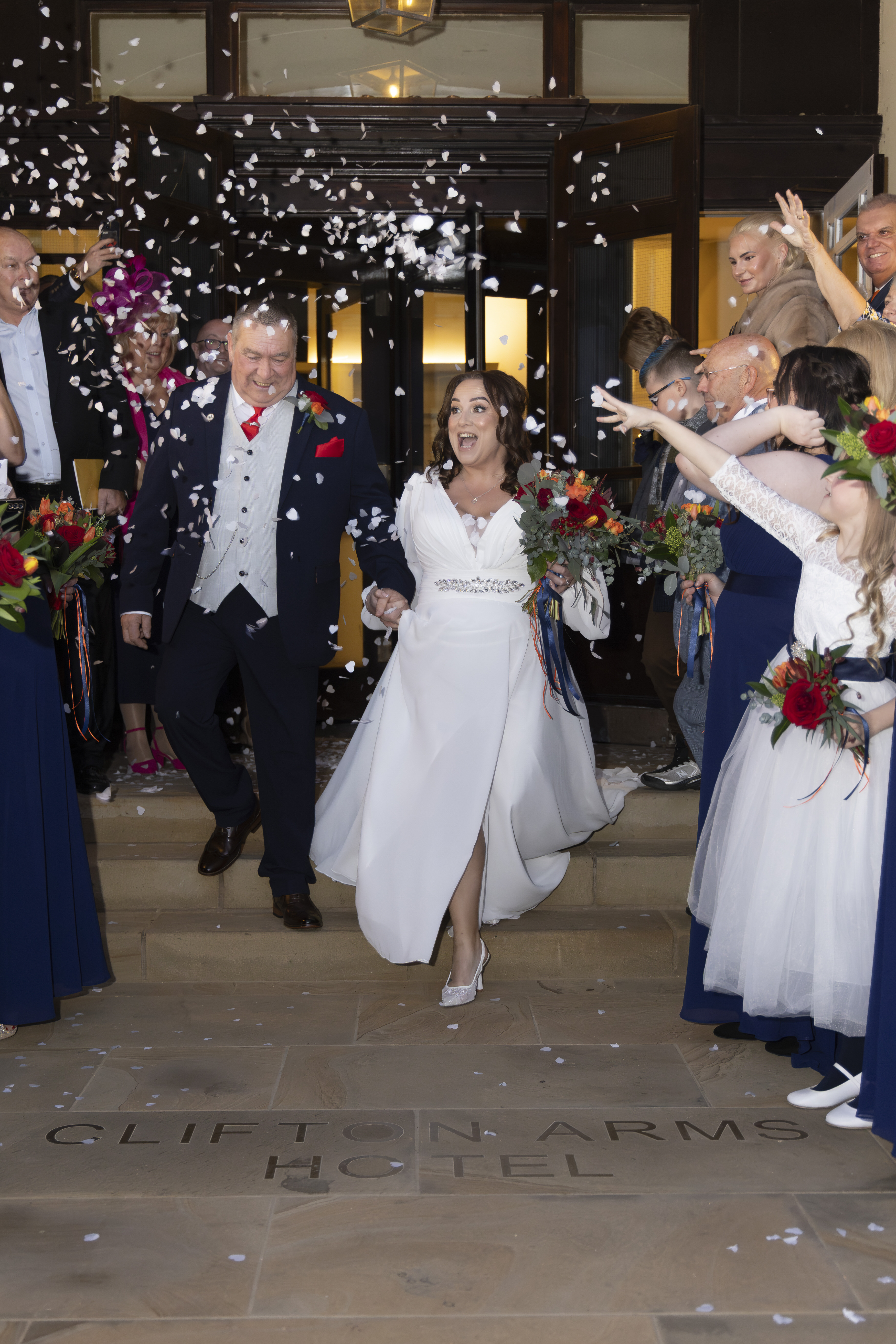 Gary and Claire are showered with confetti from their wedding guests