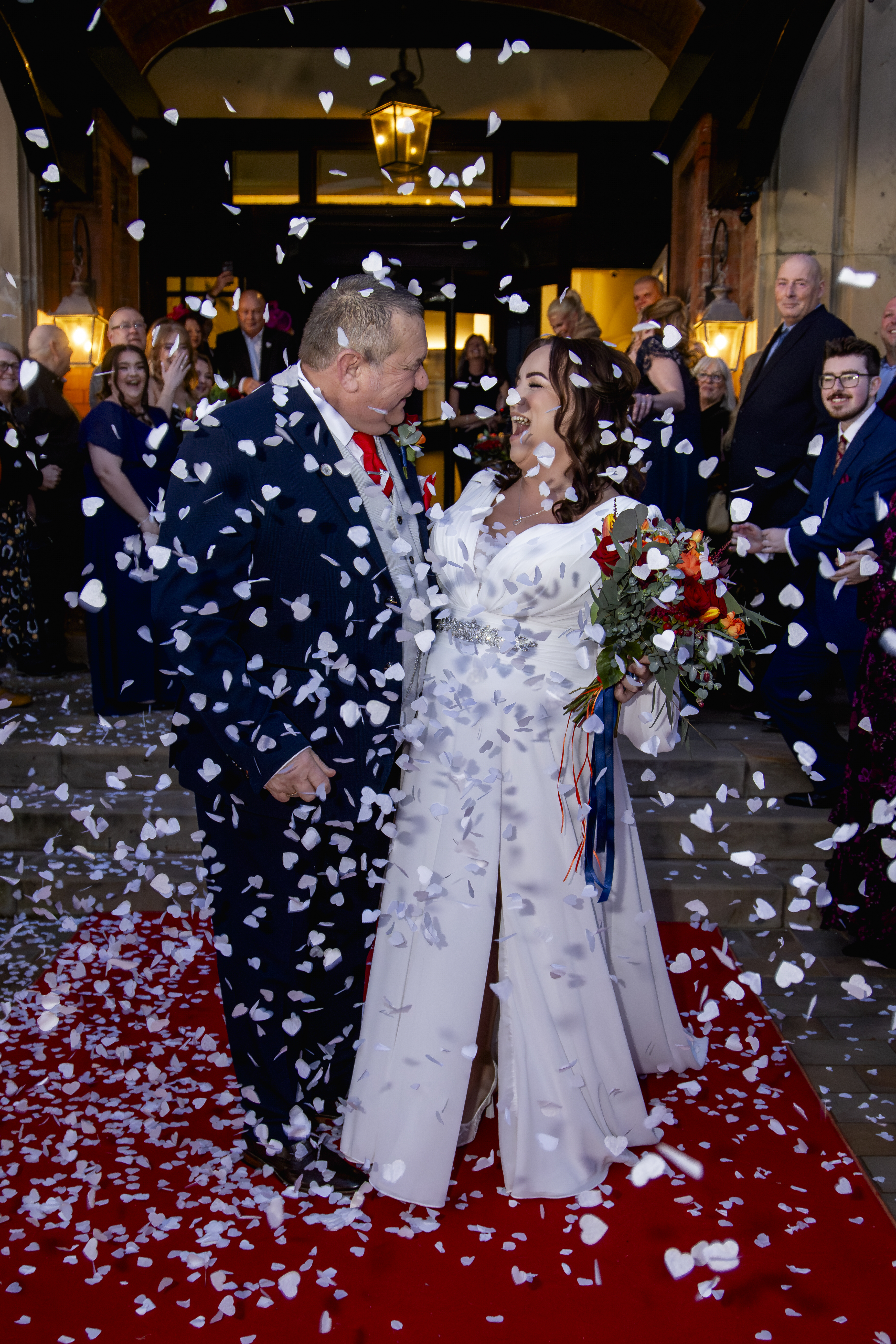 Gary and Claire are showered with confetti from their wedding guests